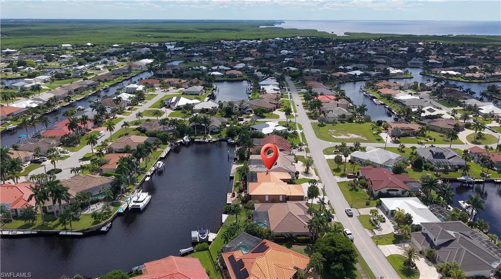 A BOATER'S PARADISE, SAILBOAT ACCESS, A SPECTACULAR CANAL VIEW, AND A CUSTOM-BUILT WATERFRONT HOME IN PUNTA GORDA ISLES. Located in the deed-restricted Bird Section, this 2,763-square-foot residence combines gracious living spaces with a distinctive waterfront setting. A charming coastal color palette creates a relaxed, welcoming feel throughout. At the back of the home, the great room looks out across the canal, while the screened lanai and recently upgraded saltwater pool create an inviting setting for relaxing or entertaining. The pool features refinished gunite, programmable lighting, and new pavers; an outdoor shower, half bath, and storage closet complete the lanai. The home is along the Christmas Boat Parade route, with views of the decorated boats from the family room and lanai.  The spacious kitchen features warm wood cabinetry, rich granite countertops, and a coordinating tile backsplash. Stainless steel appliances include a gas range beneath a statement vent hood and a built-in double oven. Glass-front display cabinetry, abundant storage, generous work surfaces, and a central island with seating make the kitchen both functional and inviting. The floor plan also offers a living room open to the dining area, a breakfast nook, and a den. A double-sided fireplace is visible from both the living room and primary bedroom. The primary suite features double doors to the lanai, two walk-in closets, and an ensuite bath with dual sinks, a walk-in shower, and a jetted tub. The split-bedroom layout includes two guest bedrooms, each with extended storage above the closet. Twelve-foot ceilings and plantation shutters add to the home’s character, while Bahama shutters accent the north- and south-facing windows.  The extended dock with Slide-Moor system, water, and electric makes boating access convenient. From Alligator Creek, a scenic boat ride through the harbor leads to Boca Grande Pass and out to the Gulf. Additional highlights include a 2023 METAL ROOF, 250-gallon UNDERGROUND PROPANE TANK, three-car garage with storage, whole-house water filtration, and whole-home storm protection, including remotely operated electric shutters at the rear. Downtown Punta Gorda, Fishermen’s Village, Sunseeker Resort, restaurants, and entertainment are nearby.