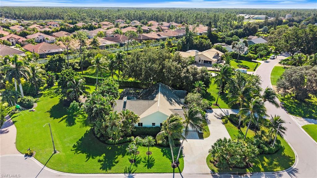 Located in the desirable community of Imperial Golf Estates, this single-family home offers over 3,000 square feet of living space featuring four bedrooms, a dedicated den, and three bathrooms. Lovingly maintained by its single owner since it was built in 1987, the residence sits on an amazing lot spanning just over half an acre. The property boasts favorable northeastern exposure that fills the home with great morning light, while the lushly landscaped yard is adorned with coconut palms and a variety of fruit trees, including lime, mango, and guava. A spacious circle driveway offers an inviting entrance and provides ample space for guest parking. Inside, the open layout features soaring high vaulted ceilings and two skylights in the main living room, creating a bright and airy atmosphere. The adjacent family room centers around a cozy fireplace adorned with floor-to-ceiling stonework, making it an ideal space for relaxing. The kitchen comes equipped with newer cabinets and countertops, conveniently positioned near a dedicated wet bar and a large walk-in pantry. Additional home updates include fully installed PGT impact windows throughout, two newer HVAC units installed in 2025, a remodeled primary bathroom, and a well system designated for irrigation. Situated in Flood Zone X, the exterior living space is rounded out by a wide paver patio pool deck that overlooks the private, serene views of the surrounding property.