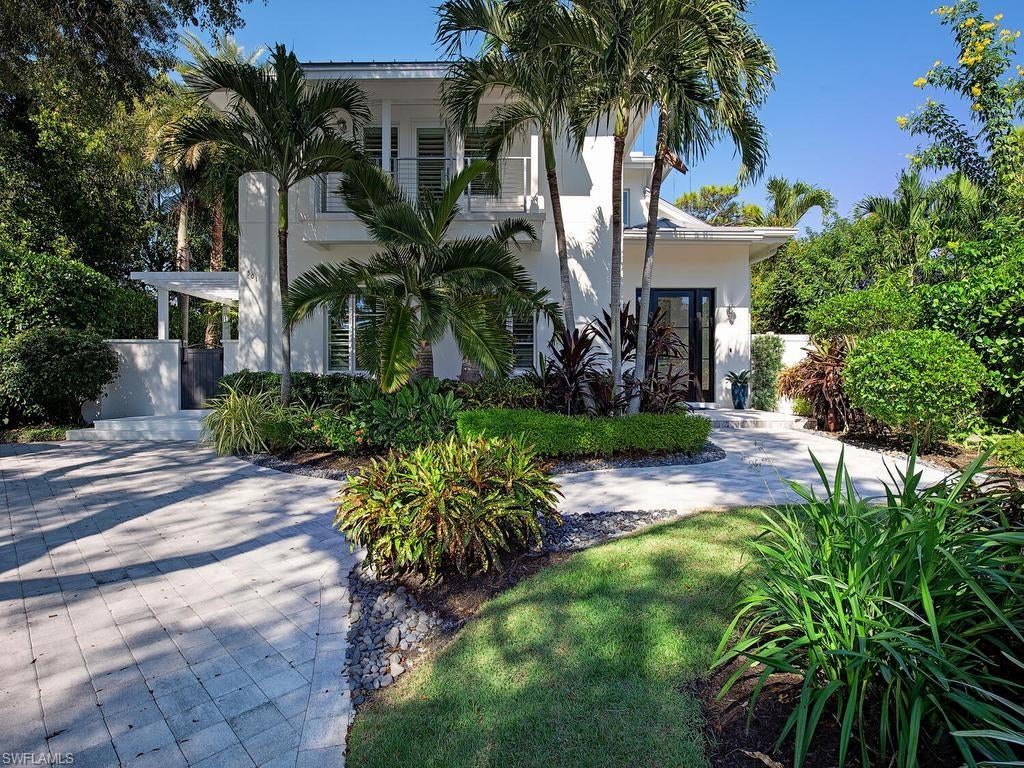 Perfectly positioned on one of Old Naples’ most sought after, mahogany-lined avenues, this coastal casual masterpiece delivers over 5,000 square feet of refined, effortless luxury living. Classic, timeless, and exquisitely finished, the light-filled open floor plan showcases a stunning great room designed for elevated entertaining. Built in 2015, this meticulously maintained residence lives better than new, featuring wide-plank wood flooring, plantation shutters, and a gourmet chef’s kitchen appointed with Wolf and Sub-Zero appliances. The indulgent, 1,000+ square foot primary suite offers a serene sitting area, an expansive walk-in closet, a morning kitchen, dual water closets, and a private covered balcony overlooking the manicured grounds. A spacious ground floor VIP suite provides flexibility for a main-level primary, and the home includes provisions for a future elevator. Thoughtfully designed with abundant storage, extensive built-ins, and two laundry rooms, the home blends practicality with sophistication. Lush tropical landscaping, palms, and curated flower and herb gardens create a tranquil backdrop for the sun-drenched pool and spa. Moments to the beach and the best of Old Naples, this exceptional residence embodies luxury living at its finest.