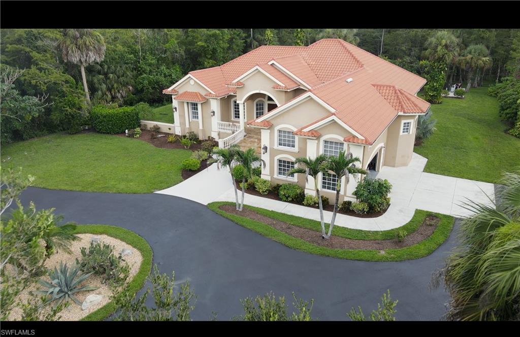 Welcome to one of the most unique properties in Golden Gate Estates.
Situated on 2.5 fully fenced acres with an electric front gate, this home offers rare dual street access, including an exceptionally wide rear entrance from Jung Blvd—ideal for RVs, boats, trailers, additional parking (including commercial vehicles), a future guest house, workshop, or other expansion opportunities.
The home was thoughtfully and solidly built on an elevated foundation and does not require flood insurance. Inside, you'll find soaring ceilings and a spacious open floor plan. The home has been meticulously maintained, with two beautifully renovated bathrooms completed in 2024.
The spacious master bedroom offers approximately 385 square feet of living space. The fifth bedroom features its own private exterior entrance and was originally constructed as a reinforced safe room. It can also serve as a gym, studio, home office, or private guest suite.
The oversized garage offers extra-high ceilings, providing excellent potential for a vehicle lift or storage.
Additional highlights include:
• Whole-house Generac generator with a 500-gallon propane tank.
• Three-zone air conditioning system with approximately two years of remaining labor warranty.
• Clay tile roof recently inspected by Kelly Roofing and found to be in excellent condition.
• Beautiful tropical landscaping with mature palms, fruit trees, and a spacious storage shed.
• The columns are decorative rather than structural, making them easy to remove if a more open-concept layout is desired.

Conveniently located just minutes from the newly completed Vanderbilt Beach Road Extension, providing faster access to shopping, dining, and beaches.

This is more than just a home—it's a rare property offering space, flexibility, exceptional quality, and opportunities that are becoming increasingly difficult to find in Naples.
