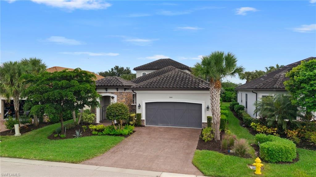 Two-story homes are rarely available in Esplanade at Hacienda Lakes, and this residence offers 3 bedrooms plus a den, 3.5 baths, and 2,843 square feet at the end of a cul-de-sac WITH A WHOLE HOME GENERATOR. A barrel tile roof, stacked stone accents, carriage-style garage doors, and a paver driveway define the exterior, while an arched stone entry and wrought-iron gate open to a paver front courtyard. Inside, modern plank tile flooring extends through the main living areas, and a dry bar in the living room provides a refined place to host. A large center island anchors the kitchen, which is finished with quartz countertops, a coordinating backsplash, white shaker cabinetry with trim detail, and stainless steel appliances including a built-in wall oven, with natural gas service in place. Along with a private den and a spacious upstairs bonus room that extend the floor plan with a full bath upstairs and newly installed whirlpool bath, the home includes carpeted secondary bedrooms and a primary suite with a custom built-in closet and a bath featuring separate vanities and a glass-enclosed shower. Behind the home, a screened lanai surrounds a newer pool with a sun shelf, and impact windows are installed for added protection. Esplanade at Hacienda Lakes is anchored by a clubhouse with a full-time concierge, a fitness center and separate aerobics room, a massage room, billiards and card rooms, and a social room with a catering kitchen. Outdoors, residents have a resort-style pool and spa with lap lanes, cabanas, and a covered lanai, along with lighted pickleball courts, a fenced dog park, a fire pit, a playground, and walking trails throughout the community. Positioned just east of Collier Boulevard off Rattlesnake Hammock Road, the community is a short drive from Gulf beaches, Marco Island, and downtown Naples, with convenient access to I-75.