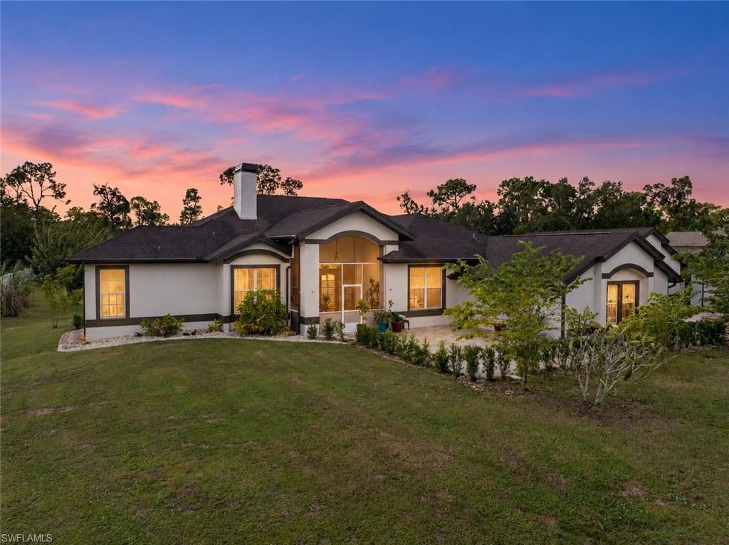 Freedom awaits! Discover the good life on 1.55 acres with AG-2 zoning and NO FLOOD INSURANCE REQUIRED in unincorporated Lee County. Located in The Woods, this five-bedroom-plus-office/den, three-bath home offers heated pool with integrated spa, oversized detached garage, 25-by-35-foot steel building, and two sheds. Enjoy acreage living with the convenience of nearby Cape Coral and no Cape Coral city taxes and rules.

An extensive brick paver patio welcomes you to the front entry. Inside, cathedral ceilings and expansive sliding glass doors create an inviting great room with views toward the lanai and backyard. The updated kitchen brings everyone together with beautiful cabinetry, granite countertops, tiled backsplash, stainless steel appliances, and generous breakfast bar with pendant lighting. The adjoining dining area overlooks the grounds, perfect for everyday meals and special gatherings.

The spacious primary suite features direct access to the lanai and adjoining office/den—your space to work, read, or retreat. The primary bath offers tiled walk-in shower, jetted soaking tub, dual vanities, and large walk-in closet. Guest bedrooms are on the opposite side of the home for added privacy, including one with its own bath. Bedrooms four and five occupy the converted garage area, accessed through the large utility room. All bedrooms are served by the home’s central air conditioning system.

Outdoor living is just as inviting. Start your morning on the covered screened lanai, spend the afternoon beside the beautiful heated pool with integrated spa added in 2020, and end the evening gathered around the fire pit. The large screened pool enclosure and extensive paver decking offer plenty of space to lounge, dine, and entertain.

Need room for your vehicles, equipment, or hobbies? The oversized detached garage and 25-by-35-foot steel building added in 2022 together offer garage space for four or more cars, plus flexibility for storage and projects. Two additional sheds provide even more room for tools, lawn equipment, and outdoor essentials.

For those who love to grow, the groundwork is already here. Established garden areas, butterfly garden, and fruit plantings—including cherry, fig, plum, dragon fruit, lemon, lime, and banana—make this property especially rewarding. AG-2 zoning adds to the appeal for horse and animal lovers, while the acreage offers room to garden, play, and enjoy the outdoors.

Space for your passions, room for your toys, and peaceful country living close to everyday conveniences—come make the good life your own!