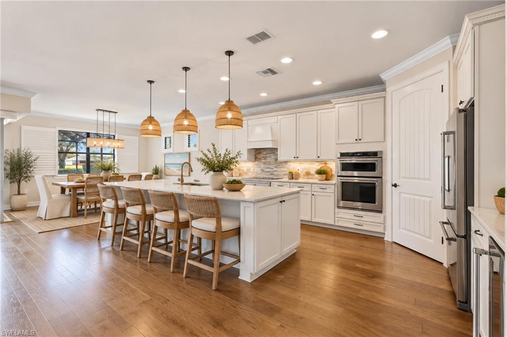 One or more photo(s) has been virtually staged, AI generated or rendered.  STUNNING TWO-STORY PINNACLE with a SALTWATER POOL & SPA and beautiful WATER AND GOLF COURSE VIEWS in the 55+ Del Webb Naples community! 
With 4 BEDROOMS, 4 FULL BATHROOMS + Den, a spacious LOFT, and a 3-CAR GARAGE, this impressive home offers exceptional flexibility for MULTIGENERATIONAL LIVING, visiting family, extended stays, a home office, media room, or additional living space. The thoughtful two-story design provides plenty of room to gather together while still giving everyone their own space. Step inside to an open, inviting living area enhanced by CROWN MOLDING, PLANTATION SHUTTERS THROUGHOUT, HARDWOOD FLOORING, a SONOS SOUND SYSTEM, and ZERO-CORNER SLIDERS with a MOTORIZED WINDOW SHADE that open to the expansive lanai, creating a seamless connection between indoor and outdoor living. 
The GOURMET KITCHEN features upgraded cabinetry, QUARTZ COUNTERTOPS, SOFT-CLOSE CABINETS AND DRAWERS, upgraded finishes, a BEVERAGE REFRIGERATOR, and OVER- AND UNDER-CABINET LIGHTING—perfect for entertaining family and friends. CUSTOM WOOD SHELVING in the pantry and closets adds both function and organization throughout the home, while the LAUNDRY ROOM offers additional cabinetry for convenient storage. A CENTRAL VACUUM SYSTEM adds another layer of everyday convenience.

Outside is where the Florida lifestyle truly shines. The spacious screened lanai features an OUTDOOR KITCHEN and overlooks the SALTWATER POOL & SPA with WATER AND GOLF COURSE VIEWS. ELECTRIC HURRICANE SCREENS provide added protection and convenience, while PRIVACY SCREENS offer additional comfort without taking away from the beautiful setting and Florida sunsets. The home is also equipped with IMPACT-RESISTANT WINDOWS, DOORS & SLIDERS, a WHOLE-HOUSE GENERATOR with 500-GALLON PROPANE TANK, and TWO A/C SYSTEMS. The spacious 3-CAR GARAGE provides even more functionality with a UTILITY SINK and additional CABINETRY for storage and organization.

This home comes with the SOCIAL MEMBERSHIP, but take note GOLF LOVERS, Panther Run Golf Club offers optional MEMBERSHIPS with premium golf experiences just steps from your backyard. In Del Webb Naples, you’ll enjoy WORLD-CLASS AMENITIES that rival luxury resorts: dine at the Rusty Putter Restaurant, soak in the RESORT-STYLE or LAP POOLS, break a sweat in the state-of-the-art FITNESS CENTER, and play your way through PICKLEBALL, TENNIS, bocce, billiards—even a top-tier GOLF SIMULATOR! Need groceries, church, or a bite to eat? Just hop in your golf cart and cruise into town—Publix and the heart of Ave Maria are just minutes away. This isn’t just a home—it’s a LIFESTYLE UPGRADE in one of Southwest Florida’s most vibrant 55+ communities. Don’t miss your chance to live where fun, fitness, and friendships flourish year-round! One or more photo(s) has been virtually staged, AI generated or rendered.
