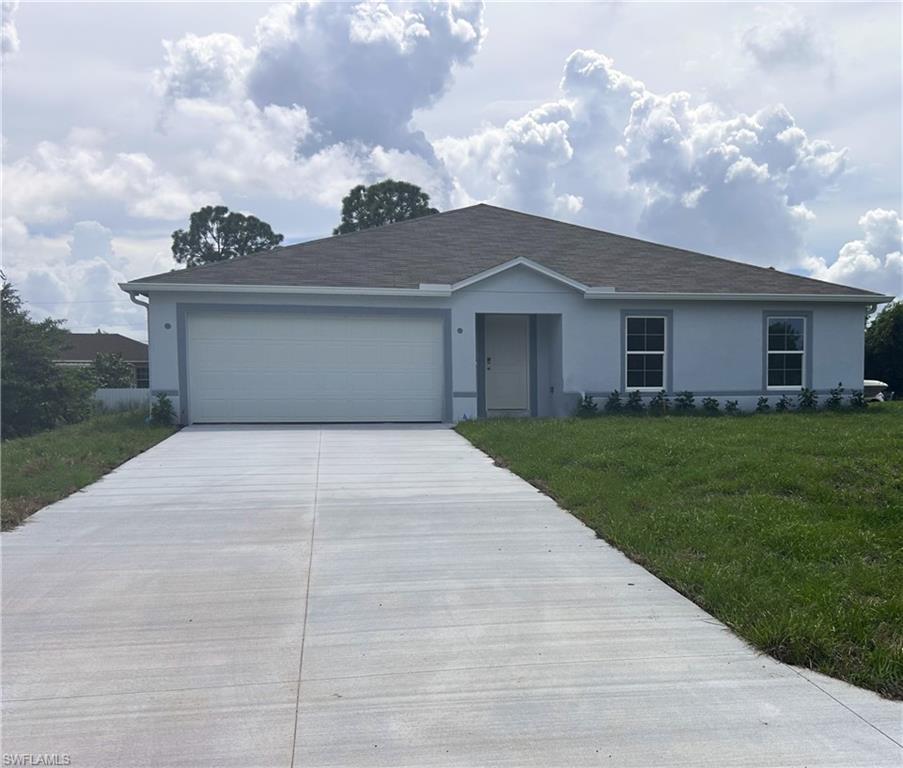 Quick Move-In Home! Fall in love with the thoughtfully crafted charm of the Orchid, perfectly situated in Lehigh Acres. Just 12 miles east of Fort Myers, this thriving community is celebrated for its natural beauty, featuring 175 miles of canals and 16 well-stocked lakes—a true haven for both avid and beginner anglers. Enjoy updated interior finishes and the freedom of No HOA and No CDD fees.

Step onto the inviting front porch and enter a bright, welcoming foyer that opens to a spacious open-concept floor plan.The expansive great room flows effortlessly into the dining area and kitchen, creating the perfect space for gathering, entertaining, and everyday living. Blinds throughout add privacy and convenience, while a sliding glass door leads to the extended patio, seamlessly extending your living space outdoors.

The kitchen is both stylish and functional, featuring a large island ideal for meal prep, casual dining, or hosting guests.

Designed for comfort and privacy, the owner’s suite is tucked at the rear of the home and includes a generous walk-in closet and a well-appointed ensuite bath. Three additional bedrooms are positioned at the front of the home, conveniently located near a full bath and a centrally located laundry room.

For modern convenience and security, the home is equipped with Smart Home features, including a Ring Video Doorbell, Smart Thermostat, Keyless Entry Smart Door Lock, and Deako Switches. Hurricane shutters, ZIP System gutters, and a full builder warranty provide peace of mind, while a spacious two-car garage offers plenty of room for vehicles, storage, or a workbench.

With its thoughtfully designed layout, seamless flow, and attention to detail, the Orchid is a home you’ll be proud to call your own.