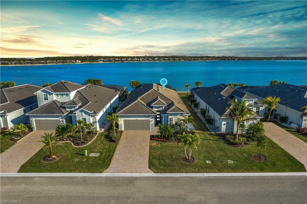 LUXURY UPGRADES THROUGHOUT! You will LOVE this beautiful waterfront setting that this pool home has to offer with a highly desired SE exposure allowing you to take in the picture perfect sunrises overlooking the 225-acre boatable & fishing lake. Enjoy this stunning outdoor living space w/ a private 16'x20' boat dock that extends your waterfront lifestyle, huge pool deck, fully custom designed 30’ x 14’ saltwater pool w/ a raised infinity spa featuring six water features, breathtaking LED lighting, swim-up bar with four pedestal seats overlooking the serene lake, volleyball-ready layout, eight-person spa for ultimate relaxation, RGB LED strip lights illuminate the pool, and pool deck creating an enchanting evening ambiance, covered area w/ mounted tv & outdoor regulation 8’ billiard table/ping-pong table, picture window screen, & water bowls spilling over into the pool (See the full upgrade/feature list attached to the MLS). A wall-mounted, back-lit 75” Sony Bravia 4K HD LED TV anchors the living room. Additional upgrades include all impact resistant windows, full alarm system for the entire house (24/7 monitoring for burglary, fire, 2 waters sensors for flooding, smoke, and carbon monoxide detectors—always ensuring peace of mind), electric remote blackout shades, gas appliances, tankless hot water heater, added insulation throughout home, UV bacteria purification system inside the A/C unit, split a/c unit in the insulated garage, entire home surge protector, high-end fans & designer grade light fixtures, tile flooring throughout, volume ceilings, & more! Vista Wildblue is a distinct gated community in a highly-desired area of SWFL. This community has access to every amenity of Wildblue -resort style pool, tennis & pickle ball complex, lap pool, poolside café bar & grill, indoor formal dining, outdoor chess, bocce ball, horseshoes, basketball courts, day spa, yoga & event lawns, fitness & aerobics centers, boat & kayak launch, playground & white sandy beach. WildBlue is one of the most desirable gated communities in SWFL with 800 acres of freshwater lakes via kayak & boat ramps, & 1300 acres of preserve. Community allows speedboats, jet skis, wakeboarding, water skiing, kayaking, fishing, tubing from your own backyard in addition to multiple community docks on the lakes.
