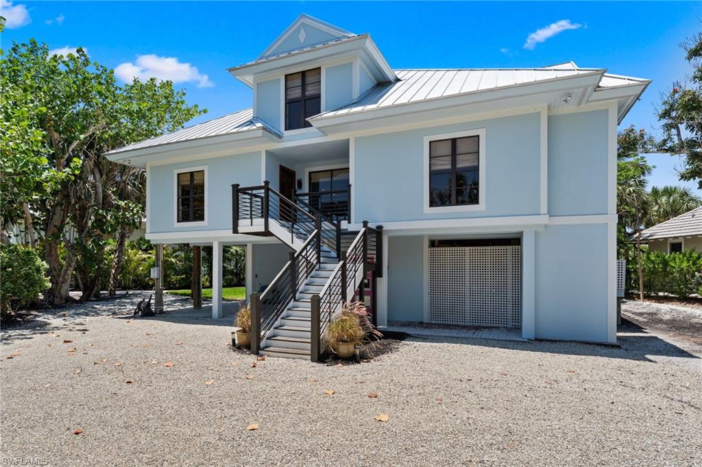 Welcome home to this most desirable east end location offering easy access on/off island, close proximity to the beach and direct boating access to the bay with a brand new 28K lb rated lift at the dock.  This elevated 4 b/r, 3 bath home is situated on a very large, lushly landscaped lot offering plenty of privacy.  The entryway boasts an ornate, solid wood door, foyer with Turkish marble and tile flooring throughout the combined living/dining/kitchen areas.  The kitchen offers a large center island with Dekton quartz countertops and countertop dining, stainless steel Viking appliances, glass backsplash, inset Shaker cabinets with under cabinet lighting and wainscoating throughout the living/dining areas.  The screened lanai off the living area, which is great for outdoor entertaining and relaxing, overlooks the canal with staircase leading to the private, fenced, resort style pool with accent lighting and shell walkway to the dock.  Main level has two bedrooms and bathrooms with marble showers, tile floors and glass accents.  The large primary suite and 4th bedroom, which could be used for an office, are on the upper level, with the primary offering a large walk-in closet, private open porch with canal views and a spacious bathroom with marble shower and tile flooring.  Additional storage is also available on this level.  The interior stairwell from main level leads to plenty of enclosed ground level storage with epoxy flooring and four ft of base concrete walls, work area and washer/dryer area, in addition to access to exterior two car carport, as well as the private pool.  The standing seam metal roof was new in 2022.  There is also an existing elevator, however not working at this time and estimate for repair to be provided.  Very close to the Sanibel Marina, Grama Dot's, Wickies Lighthouse Restaurant, Magic Bus Ice Cream & Caffeine, shopping and much more!  Prime location for year-round, seasonal living or vacation rental!!!