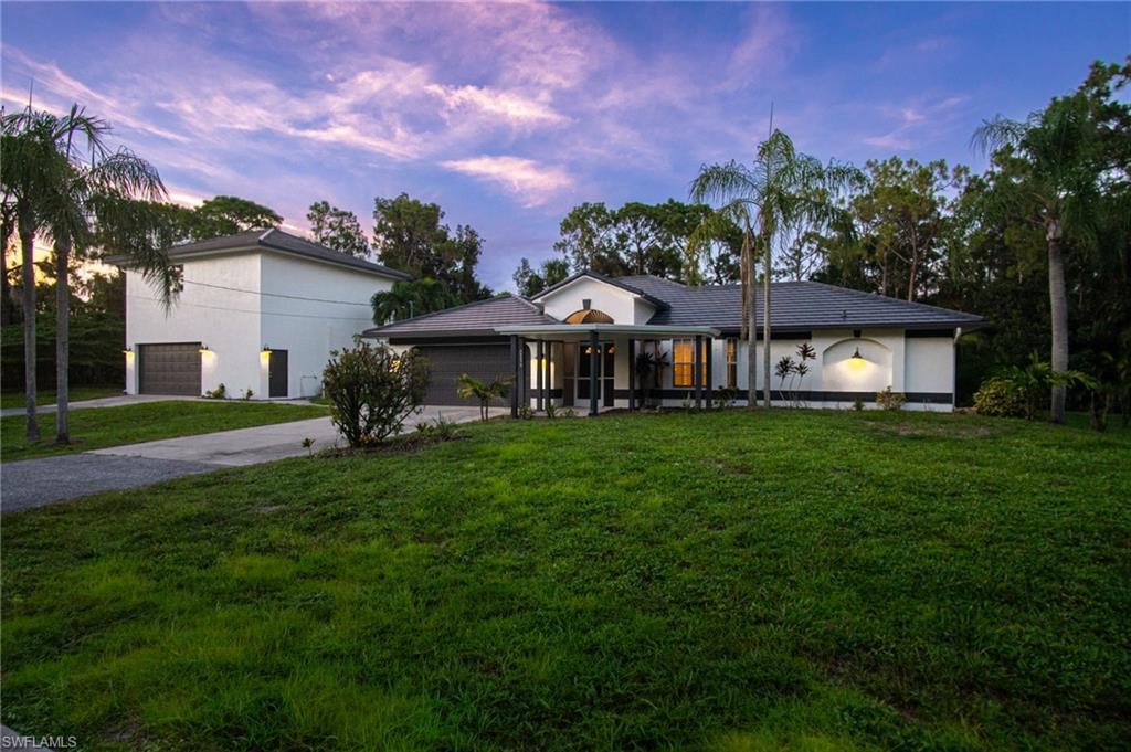 One or more photo(s) has been virtually staged, AI generated or rendered.  RARE “SAN CARLOS ESTATES” COMPOUND ON 1.81 ACRES! This UPDATED BONITA SPRINGS POOL HOME features a 3-BEDROOM, 2-BATH MAIN RESIDENCE PLUS A DETACHED 30X28 CONCRETE BLOCK WORKSHOP/GARAGE WITH A GAME ROOM/1-BEDROOM EFFICIENCY APARTMENT ABOVE—APPROXIMATELY 2,742 SQ FT OF TOTAL LIVING AREA AND GARAGE CAPACITY FOR UP TO 6 CARS! Tucked along a quiet dead-end paved street, enjoy exceptional PRIVACY, SPACE & NATURE with mature landscaping and fruit trees, while remaining minutes from Coconut Point, The Promenade, beaches, shopping & dining. Major updates include a NEW 2023 BRAZILIAN CERAMIC TILE ROOF, NEW FRENCH OAK-LOOK TILE FLOORING, NEW INTERIOR PAINT (2026), EXTERIOR PAINT (2024), updated kitchen appliances, NEW WATER HEATER, WASHER/DRYER and pool pump. The SHOWSTOPPING PRIMARY BATH WAS COMPLETELY RENOVATED IN 2026 with BRAND-NEW quartz counters, white cabinetry, marble-look tile, subway tile detailing and a NEW glass shower enclosure. HIGH CEILINGS, plantation shutters, abundant natural light, screened POOL, 2021 irrigation, dual septic systems, AG-2 ZONING & NO HOA complete this one-of-a-kind property!