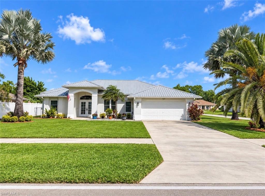 Over 2100 square feet of living area in this 3 bedroom 2 bath POOL HOME features formal living room and dining room, newly remodeled kitchen with QUARTZ COUNTERTOPS, NEWER CABINETS WITH SOFT CLOSE DOORS AND DRAWERS, STONE TILE BACKSLPASH, BREAKFAST BAR AND PANTRY, stainless steel appliances with French Door refrigerator and double oven, FAMILY ROOM AND NOOK AREA OPEN TO THE KITCHEN AND POOL AREA, porcelain tile wood plank floors throughout, 5 inch baseboards and carpet in the bedrooms, newly remodeled bathrooms with QUARTZ TOPS, new vanities and fixtures, primary bedroom with sliding door access to the pool and lanai area, private ensuite bath with dual sinks, separate soaking tub and tiled walk in shower, dual walk in closets, LED light fixtures, CROWN MOLDING ACCENTS THROUGHOUT WITH HIGH VOLUME CEILINGS,  NEW METAL ROOF IN 2018, NEW WATER HEATEER IN 2026, NEW CENTRAL HEAT AND AIR IN 2025, 9 NEW IMPACT WINDOWS AND ONE SIDE GARAGE DOOR IN 2025, SCREEN ENCLOSED IN GROUND HEATED POOL, recently refinished with Diamond Brite coating, plenty of open and covered deck space for entertaining, pocket sliding doors, double garage with opener, indoor laundry room with laundry tub,  beautifully landscaped CORNER LOT with plenty of palms including Bismarck palms and a large CANARY PALM, excellent location with CENTRAL WATER AND SEWER, SIDEWALKS IN FRONT, located just minutes to stores, schools, I-75, Ft Myers and The SWFL International Airport.  NO FLOOD INSURANCE REQUIRED. LEHIGH IS THE HIGHEST ELEVATION IN LEE COUNTY.