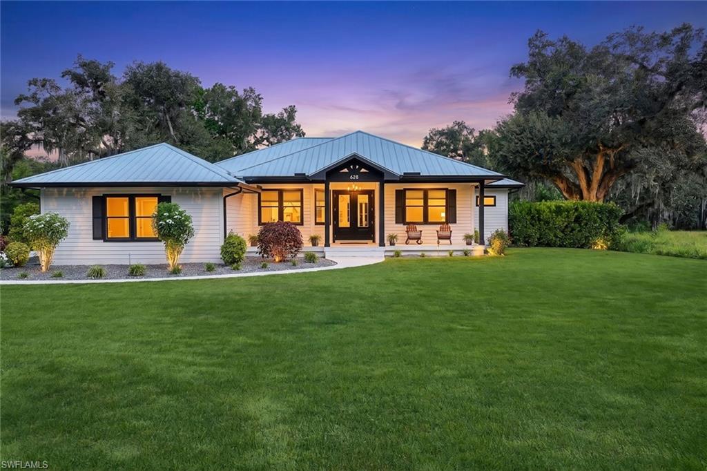 Stunning custom-built home, crafted in 2023 by Daniel Wayne Homes and situated on a picturesque inlet off the Caloosahatchee River. This 3-bedroom plus den retreat blends thoughtful design with exceptional outdoor living for the ultimate Florida lifestyle. Step inside to soaring vaulted ceilings in the living room and wide-plank engineered wood flooring flowing throughout the home. The enclosed den offers flexible space for a home office or study. The kitchen features Café series appliances, double ovens, a wine cooler, farmhouse sink, pot filler, expansive island, and a large walk-in pantry — perfect for everyday living and entertaining alike. The primary suite is complete with a spacious walk-in closet and French doors opening directly onto the rear verandah, seamlessly connecting indoor comfort to outdoor living. Outside, escape to your own backyard: a large saltwater pool and spa, a covered verandah with a full outdoor kitchen and dining space, a putting green for practicing your short game, plus an additional gazebo for relaxing or entertaining under the stars — all with a tranquil breeze coming off the river. A dock can be added for direct river access, making this a boater's dream. Additional highlights include an oversized 2.5 car garage (22x27), whole-home reverse osmosis system, 13x13 covered pole barn with an attached custom-built lawnmower shed, and a generous lot with ample room to build another pole barn or additional garage. Located just 30 minutes east of Fort Myers, 1.5 hours to West Palm Beach, and 2 hours to Tampa — enjoy the peace and privacy of riverside living with easy access to Florida's best coastal cities. This property is located in an X500 flood zone, indicating it is less susceptible to potential severe flooding.