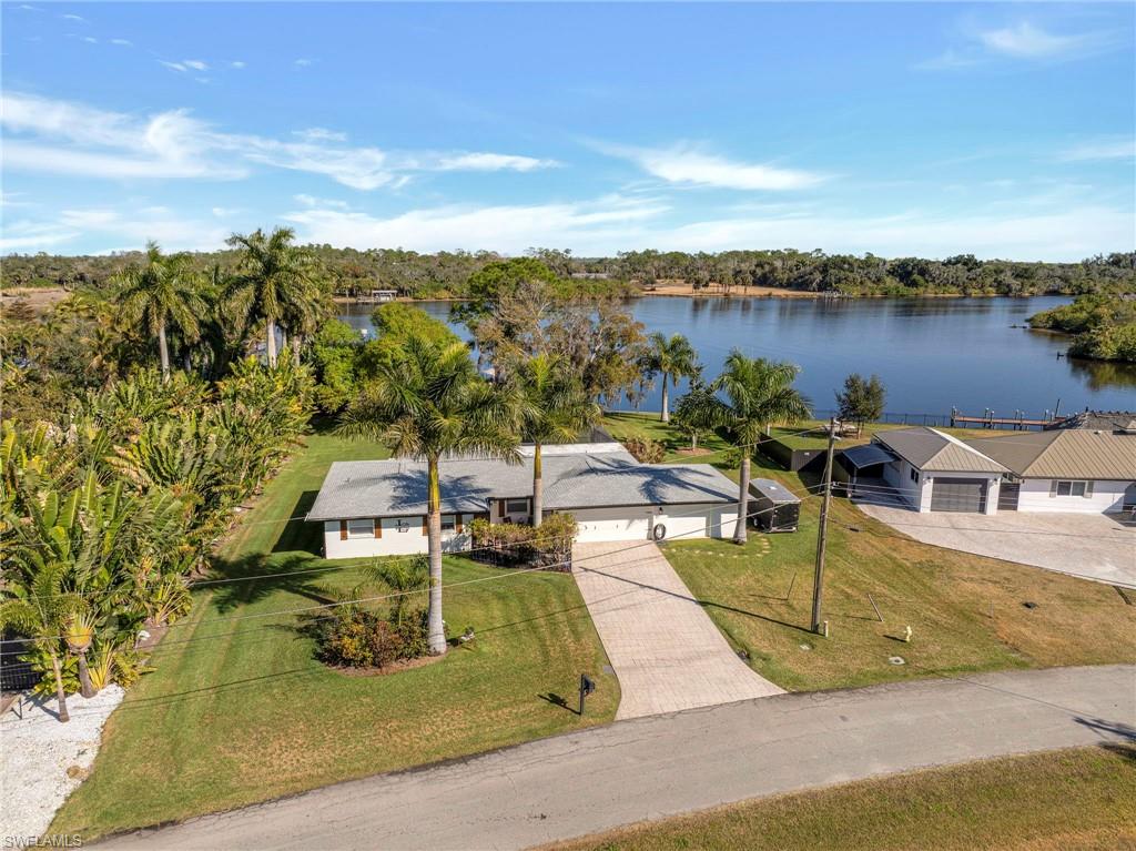 Experience true Southwest Florida waterfront living with this exceptional direct riverfront property offering immediate boating access to the Caloosahatchee River and the Gulf beyond. Set on over half an acre, this oversized homesite provides rare space, privacy, and flexibility to enjoy the lifestyle you’ve been dreaming of.

With unobstructed river frontage, this property is ideal for boating enthusiasts seeking open water access right from their backyard, all while tucked within a quiet residential setting. Mature trees and expansive yard space create a peaceful, private atmosphere, and in the evening the property transforms into a beautiful retreat with solar lanterns hanging from the oaks and thoughtfully placed landscape lighting throughout the grounds.

Inside, the home has been extensively updated, offering a move-in ready interior with quality finishes throughout. Porcelain tile flooring runs through the main living areas, providing both durability and a clean, modern aesthetic, with tile in the bathrooms for a cohesive look. The home also features a new roof (2022) and new AC system (2022), adding significant value and peace of mind. Additional updates include doors, trim, cabinetry, sinks, and appliances, all contributing to a cohesive and refreshed interior.

Large windows fill the home with natural light and showcase expansive river views, while the functional layout supports comfortable everyday living. An electric interior fireplace adds warmth and ambiance, creating an inviting focal point in the main living space.

With generous space, direct waterfront access, and no high-density surroundings, this property is well suited for those seeking privacy, long-term value, and a true Florida lifestyle. Whether you’re searching for a primary residence, seasonal retreat, or waterfront investment, this home offers a rare combination of location, updates, and natural beauty.