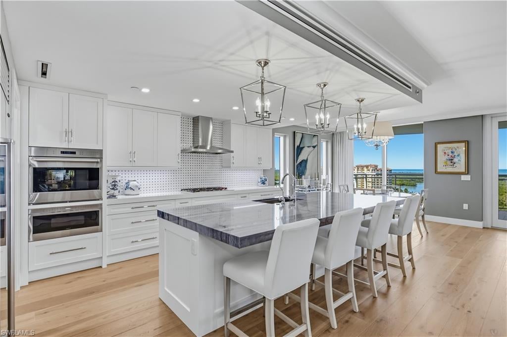 TIMELESS COASTAL ELEGANCE AT KALEA BAY. Beautifully appointed and effortlessly sophisticated, this four-bedroom, four-bath residence with an additional den in Tower 100 offers a refined interpretation of luxury coastal living. A harmonious palette of crisp whites, soft neutrals, and signature coastal blues creates an inviting atmosphere, while tailored furnishings, rich textures, elegant wallcoverings, and thoughtfully selected designer accents bring warmth and character throughout.

The expansive great room is designed for both gracious entertaining and relaxed everyday living, seamlessly connecting the living and dining areas with a beautifully finished open kitchen. Natural light fills the residence, highlighting the warm wood flooring and timeless architectural details. The serene owner’s suite offers a private retreat, with expansive windows framing breathtaking views across the mangrove preserve to the Gulf of Mexico and spectacular Southwest Florida sunsets. A spa-inspired owners bath and thoughtfully designed custom closet further enhance the sense of luxury. Each guest ensuite bedroom offers its own distinctive character, including elegant wallcoverings and classic coastal detailing.

A standout feature is the sophisticated den, where a stunning custom wood coffered ceiling adds architectural warmth and distinction. With its rich finishes, tailored details, and abundant natural light, this versatile space is equally suited for a private office, intimate lounge, or quiet retreat with incredible east facing views of the sunrise over the Kinsale Golf course.

The expansive lanai extends the home’s beautifully coordinated interiors outdoors, featuring a distinctive wood-accented feature wall, generous seating areas, and sweeping views across the lush mangrove preserve toward the Gulf. Whether enjoying morning coffee, entertaining friends, or watching the sun set over the water, this inviting outdoor living space perfectly captures the essence of the Naples lifestyle.

Beyond the residence, Kalea Bay offers an extraordinary resort lifestyle with a spectacular private clubhouse, three pools, two restaurants, open-air bars, a state-of-the-art wellness center, tennis and pickleball courts, and exceptional recreational amenities. Tower 100 residents also enjoy exclusive rooftop amenities, including a pool, fitness center, and gathering spaces with panoramic views. An exceptional opportunity to experience the timeless elegance, sophisticated interiors, and unparalleled resort lifestyle that define Kalea