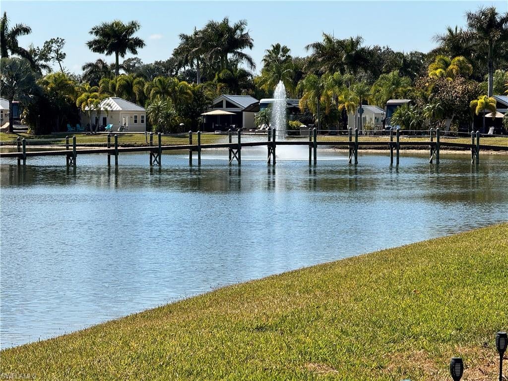 Let me tell you a little story about Lot 144, Imagine turning onto a quiet little street where coach houses line only one side and a lush tropical preserve stretches along the other. It feels peaceful, private, like you’ve stumbled onto your own hidden retreat. And then you see it,the lake view. Sun dancing on the water. A gentle breeze moving through the palms. That’s when you know you’re home. The entire lot is beautifully pavered, framed with newer palms and landscaped beds on both sides, giving you just the right touch of privacy from your neighbors. It’s polished, but relaxed. Tropical, but easy. Now step inside the coach house and here’s where the charm kicks in. Warm wood accents give it that cozy cabin feel, complete with a Murphy bed ready for guests. There’s a convenient bathroom, a mini kitchenette, shelving for your favorite books and treasures, plus a movable bar with stools and a TV, because happy hour should always be flexible. But the real magic? The enclosed screen room with direct access into the coach house. This is where mornings begin with warm coffee and soft lake views. It’s where afternoons drift by with a tropical breeze and maybe a little nap. Evenings? That’s when conversations linger, laughter carries, and the Big Green Egg gets fired up for smoked ribs or the perfect steak. Rain stays out. Pests stay out. Good times stay in. And when you feel like taking a break from cooking? A short stroll brings you to the River Clubhouse where friends, good meals, and a lively seasonal social calendar is waiting for your to enjoy. Afternoons might find you poolside with a beverage from the cabana, soaking in the Florida sunshine. Beyond your own slice of paradise, the RiverBend lifestyle unfolds along the peaceful shores of the Caloosahatchee River. Think sunset strolls, boat watching, and that calming river breeze. The resort pool, hot tubs, and River Clubhouse buzz with live music, trivia nights, themed dinners, and holiday celebrations at the River Clubhouse. Pickleball, bocce, Zumba, line dancing, Creations Guild, remote control boating on the lake, the RC race track, and Texas Hold ’Em nights, there is always something happening. Even your four-legged friends have their own beautifully maintained dog park. Lot 144 isn’t just a property. It’s sun on the water. It’s quiet enjoyment. It’s entertaining with ease. It’s morning coffee, afternoon naps, smoky barbecue evenings, and a community that feels like vacation every single day. This is waterfront Class A motorcoach living that is wrapped in charm, comfort, and just the right touch of playful paradise.