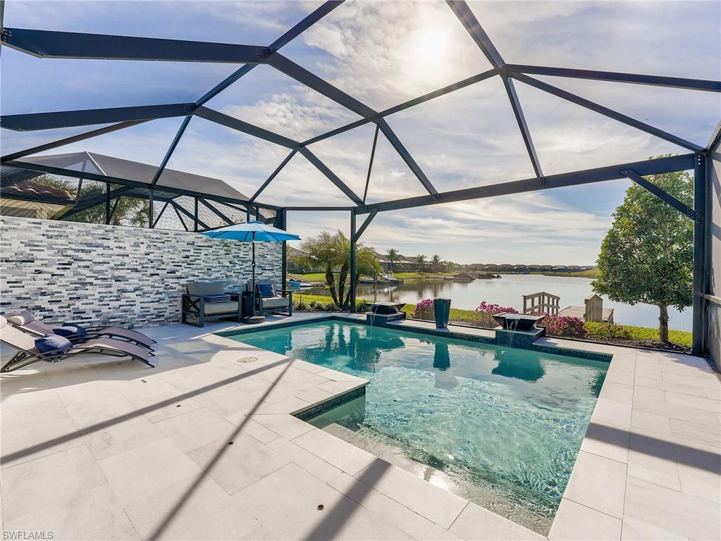 Experience the ultimate waterfront lifestyle at a significantly lower price point than comparable lake-access homes. Located in the prestigious Esplanade Lake Club, this 2021 "Ellenwood" villa is a high-tech masterpiece featuring a private boat dock with direct access to over 800 acres of lakes featuring Lake Como. The unique lot setbacks and strategic views create an exceptionally private setting.
Inside, enjoy premium plank tile flooring and a professional tech suite including 8 hard-wired (Cat 5) TVs—highlighted by a 75” Samsung Frame—and a Sonos sound system. The backyard is an entertainer’s dream, boasting an expanded travertine lanai, wood-plank ceilings, and a stone accent wall. Relax by the custom pool with cascading waterfalls, managed via the Aqualink system and framed by a "picture window" screen for unobstructed, long water views down the canal. The outdoor kitchen comes fully equipped with a built-in grill, fridge, and sink. Home has hurricane impact windows and doors throughout for piece of mind. 
This home offers resort-style living with a waterfront bar/grille, private beach, and sports courts. Skip the wait for new construction and enjoy elite luxury with low HOA fees and county-only taxes. This move-in-ready gem is priced to sell in one of SWFL’s most sought-after communities!
