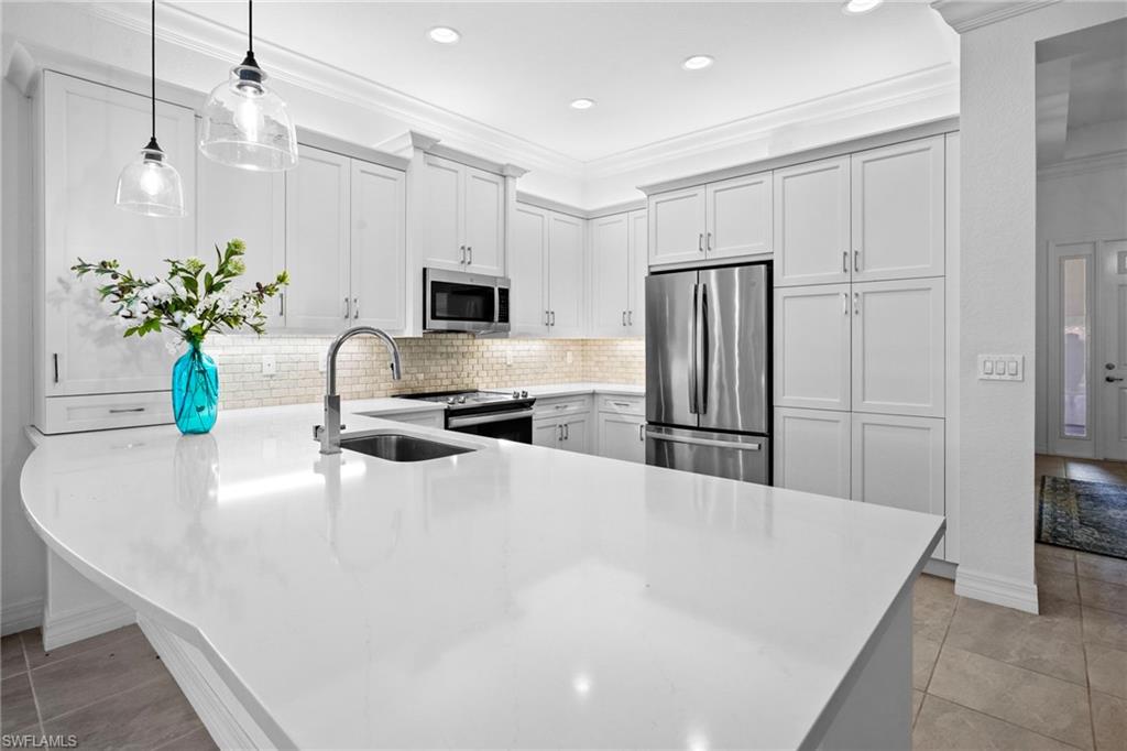 Experience refined living in this Cayman model located in Marina Bay. Offering 2,242 square feet, 4 bedrooms, and 3 baths, this residence features an open-concept layout, designer finishes, crown molding, tile flooring throughout, and custom cabinetry.  The chef-inspired kitchen showcases upgraded cabinetry, extended storage, a custom pantry, and a stunning marble backsplash. The luxurious primary suite offers tray ceilings, dual walk-in closets, and a spa-like bath with dual vanities, soaking tub, and walk-in shower.
Oversized sliding doors open to an expansive 15' x 35' lanai overlooking serene lake and fountain views, creating the perfect setting for indoor-outdoor living. Enhanced with professional landscaping, frameless shower enclosures, and countless custom upgrades, this exceptional home is truly move-in ready. Ideally located in the sought-after Marina Bay community, this residence offers convenient access to everything Southwest Florida has to offer. Just minutes from Southwest Florida International Airport, JetBlue Park, shopping, dining, fitness centers, and everyday conveniences, you'll also enjoy close proximity to beautiful beaches, parks, top-rated schools, and local colleges.  Whether you're seeking a full-time residence or seasonal retreat, this exceptional property delivers the perfect blend of luxury, comfort, and location. Experience the Southwest Florida lifestyle at its finest with low HOA Dues.