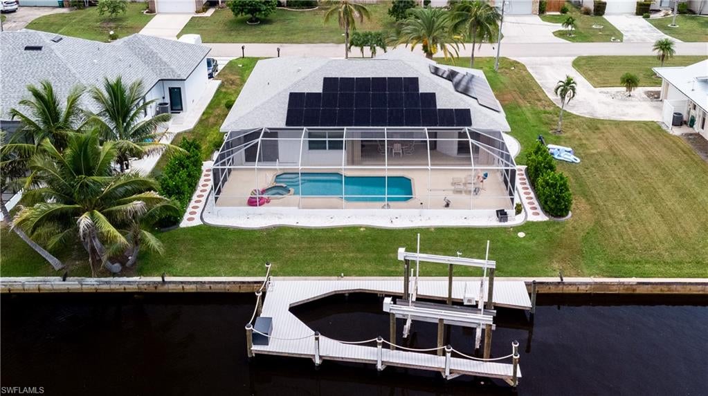 Welcome to this beautifully improved waterfront residence in Southeast Cape Coral, offering prime boating access and extensive recent upgrades exceeding $175,000 in value. Ideal for year-round living, a vacation retreat, or investment, this move-in-ready home delivers the Southwest Florida lifestyle. Bring your large boat—this property features a private 20,000-lb. lift and is just minutes from the Gulf.

Situated on the extra-wide 120-foot Meade Canal, the home offers a direct, bridge-free route to the Caloosahatchee River and Gulf, with only one turn to open water.

The inviting front porch features elegant pillars and a large concrete walkway. Inside, the open layout includes tile flooring throughout the main living areas, vaulted ceilings, ceiling fans, and a desirable split-bedroom floor plan. The bedrooms feature carpet with thick padding. The private primary suite offers a tray-box vaulted ceiling, separate tub and shower, bidet, walk-in closet, and direct lanai access. The lanai is also accessible from the second bedroom, dining area, and living room for seamless indoor-outdoor living.

The kitchen features a two-tier center island with new quartz countertops, refreshed cabinetry with new doors and drawer fronts, and a new refrigerator with two ice makers. The laundry room includes a new washer and dryer. Boating amenities include a new dock with composite decking, water and electricity, and a 20,000-lb. lift suitable for larger vessels.

The outdoor living area features a large heated saltwater pool and spa surrounded by an expansive concrete deck. The spacious lanai offers room for an outdoor kitchen and is enclosed by a heavy-duty screened cage. Hurricane accordion shutters protect the lanai and pool area. The pool system has been upgraded with a new pump, filter, saltwater conversion system, and Pentair IntelliCenter automation.

The primary bathroom includes a renovated shower. New window coverings are installed throughout, including a sliding blind covering the full set of sliding doors to the lanai. Additional improvements include new hurricane-impact windows, a new front door, new solar electrical system, new water heater, and freshly painted complete exterior. The garage offers an overhead storage rack. Roof and air-conditioning system were replaced in 2022.

Beautiful landscaping includes fresh rock, attractive curbing, graceful palms, and a striking Canary Island date palm in the front yard. Conveniently located near restaurants, medical facilities, shopping, everyday services, and Southwest Florida’s Gulf beaches, this exceptional property offers boating, recreation, and coastal living at its best.