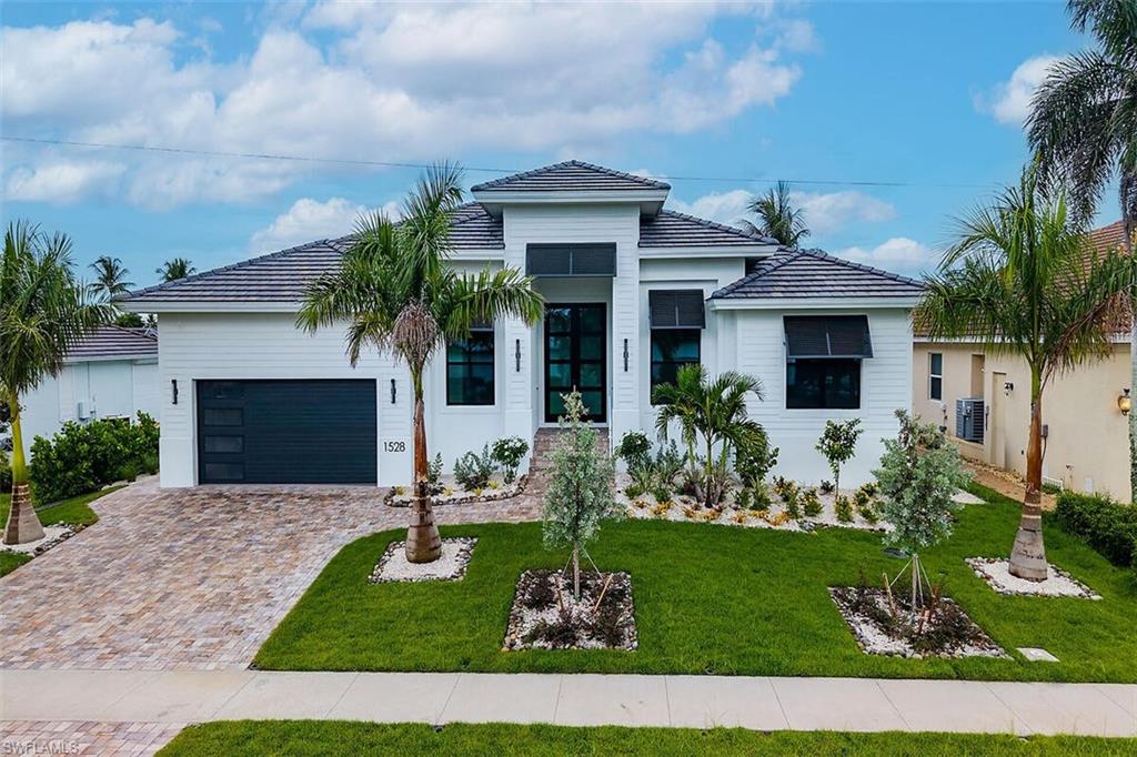 One or more photo(s) has been virtually staged, AI generated or rendered.  Centrally located, near the YMCA and white sandy beaches, in a popular water indirect neighborhood, this brand new residence boasts tons of upgrades. Built by FCI Homes and completed in September 2026, this modified St. Bart's great room model epitomizes luxury living and features four bedrooms, three and a half baths, and an array of upgraded including built-in appliances, radiating modern, coastal elegance. The expansive kitchen island invites culinary adventures, complemented by 10-foot sliding glass doors that flood the great room with natural light. Throughout the neutral hues create a serene ambiance, while outdoor amenities such as a fireplace, pool, spa, and outdoor kitchen beckon for entertainment. The home was built to an 11 foot elevation and offers a beautifully landscape retaining wall. The property presents an exceptional opportunity to embrace the relaxed, tropical lifestyle synonymous with Marco Island.