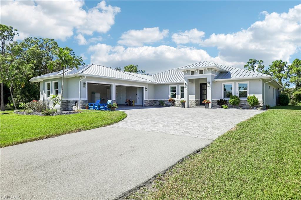 Custom-built 2.5-acre estate home with all the city conveniences, constructed to the highest standards in 2021. The home has 4 bedrooms and 3 baths, plus an office and a workout room that could serve as a 5th bedroom.

Extensive trim detail runs throughout, with coffered ceilings, tray ceilings, crown molding, shiplap walls, and decorative tile. The chef's kitchen features a large island, a walk-in pantry, a 48" GE Café Series refrigerator, and a 48" propane range with double oven. LVP flooring and 5-panel Shaker solid-core doors carry throughout the home, and the living room features a built-in electric fireplace.

A pocket corner slider opens to your private resort with an upgraded pool package. The salt water, electrically heated pool and oversized 7' x 9' heated spa sit on marble pavers under a picture-window cage. Upgrades include a 7' x 14' sun shelf, water fountains, bubblers, and LED lighting, all controlled from the Pentair app. There's also a propane fire pit and an outdoor kitchen with a Bull grill and double-drawer refrigerator, all beneath a Synergy wood ceiling that carries through the entry and the entire lanai.

The 3-car attached garage has a full epoxy flake floor and a Tesla plug. In addition, a 3,000 sq ft concrete block detached garage, offers three bays with 12' doors and an RV plug.

Built for Florida living, with a standing seam metal roof, impact windows, spray foam insulation, a whole-house generator with a 1,000 lb propane tank, 2 AC units, and a tankless water heater. Stucco and Hardie board siding, a camera system, and custom surround sound round it out. The property also has a paver driveway, a fence with an automatic gate, a sprinkler system, city water, and an irrigation well, and Comcast Business internet is available.

NO HOA FEES! The house was removed from the flood zone through a FEMA Letter of Map Revision (LOMA). Property is zoned AG-2. It's 5 minutes to the new Lee Health Fort Myers hospital, a state-of-the-art campus being built with hurricane-resistant infrastructure and room for growth. Newer homes like this on acreage are rare, so schedule your showing today!