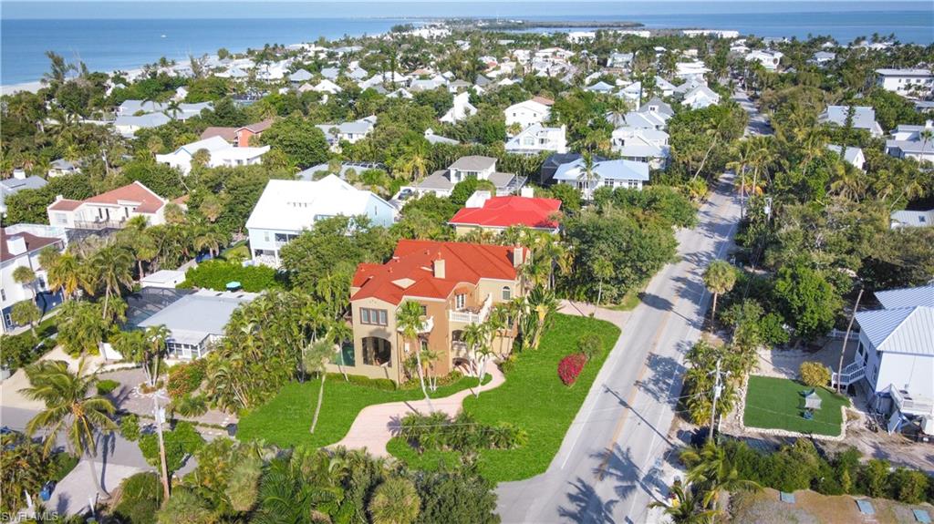 Experience the timeless coastal allure of 15160 Captiva Drive, a stunning estate designed with a rare reverse floor plan to capture sweeping bay views from its multi-level decks. This 6-bedroom + den, 6.5-bath residence offers more than 4,800 square feet of refined living space, blending elevated design with effortless island living. Crafted in Coastal-Tuscan style, the home showcases travertine flooring in the main living areas, warm wood flooring in the bedrooms, and soaring 10+ ft ceilings with detailed crown molding. The thoughtful layout features multiple living rooms, all ensuite bedrooms, an elevator, a morning kitchen, and a private in-law suite—ideal for hosting with comfort and privacy in mind. The chef’s kitchen is beautifully appointed with a gas cooktop, stainless steel appliances, granite countertops with breakfast bar seating, custom wood cabinetry, a walk-in pantry, oversized sink, and a dedicated bar area for seamless entertaining. Step outside and enjoy the best of the #IslandLifestyle with a private pool and spa, spacious covered and open patios, and effortless beach access just a short walk away. Perfectly positioned near Captiva Village, beloved island restaurants, and boutique shopping, this residence embraces everything that defines the #CaptivaLifestyle.