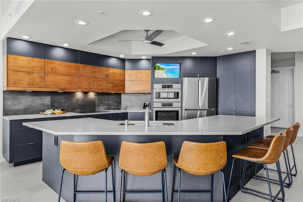 Totally renovated with designer touches at every turn, this stunning condo offers a sophisticated, modern finish throughout. Features include counter-height quartz surfaces, 24" x 48" porcelain tile flooring, European-style cabinetry in the kitchen, baths and custom built-in dry bar with wine cooler, upgraded designer lighting, electrical, hardware and blinds. The sleek kitchen showcases Bosch appliances, a porcelain tile backsplash and a built-in entertainment nook—perfect for enjoying your morning coffee while catching up on the news. The luxurious primary bath features dual walk-in showers with dual showerheads, custom electric lighted mirrors and European cabinetry. Two parking spaces and oversized storage as well. 

Residents enjoy over 15,000 sq. ft. of resort-style amenities across 12.5 lush waterfront acres, including a two-level clubhouse, private theater, business center, fitness and aerobics facilities, steam rooms, pickleball, tennis and bocce courts, plus a heated south-facing pool and spa. Marina slips are available for lease. Stroll along the marina to four waterfront restaurants or take the free seasonal trolley to the Fort Myers River District, home to more than 60 restaurants, boutiques, galleries, theaters and entertainment venues.