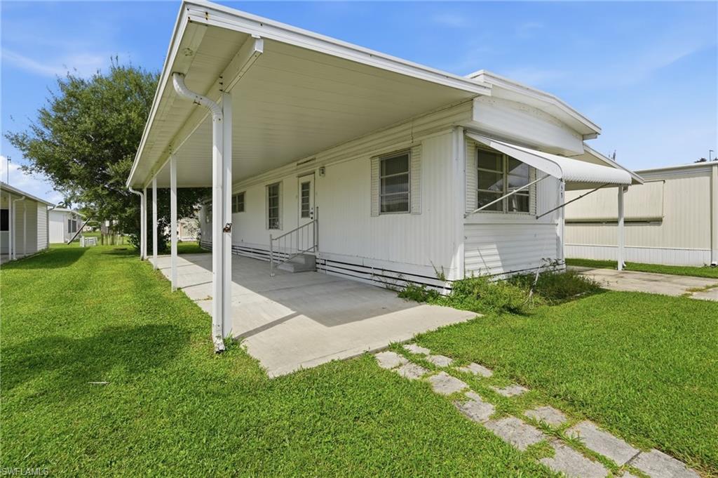 Holiday Manor is an active 55+ cooperative community in South Naples, and this 2-bedroom, 1-bath home sits on a quiet interior lot with a paved drive and attached carport.

The 672 sq ft main home opens into a permitted 400 sq ft enclosed Florida room — fully conditioned by both central air and a window unit, with a door leading straight into the living room. 1,744 total sq ft under roof.

A separate 332 sq ft cabana offers storage or workshop space. The aluminum carport was replaced in 2018 and the central A/C system was installed in 2016, both under county permit. Additional features include an A.O. Smith water heater, washer/dryer hookups in the utility room, and awning and single-hung windows.

Community amenities include a pool and spa, clubhouse, exercise room, billiards, shuffleboard, common laundry, and boat dock, ramp and storage on Henderson Creek.

The $180 monthly fee covers water, sewer and lawn service. Offered furnished. This is a cooperative share purchase — cash only. Buyer application and association approval required; the association has 15 working days to review. No pets permitted per association rules. At least one occupant must be 55 or older.