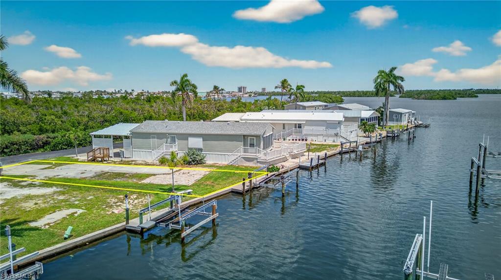 Build your dream coastal retreat in Port Carlos Cove, an intimate, resident-owned 55+ co-op community of just 155 homes on Hurricane Bay, only a short walk from the white sands of Fort Myers Beach. One of the larger lots in the neighborhood, this premium waterfront property offers extra space, a private boat lift, and direct Gulf access with no bridges. Reach open water in under 10 minutes and enjoy easy access to the backwaters of Estero Bay as well as the Gulf. The boat lift structure is sound, although the motor may need replacement.

The lot is cleared and ready for a site-built or modular elevated home. FEMA-compliant construction allows valuable space below for covered parking, storage, or outdoor living. With no homes directly across the street, the property enjoys a more open setting, added privacy, and less passing traffic.

Port Carlos Cove offers an active, social lifestyle centered around boating and waterfront living. Residents enjoy a renovated clubhouse, heated community pool, pickleball and bocce courts, shuffleboard, a community boat ramp, dedicated storage areas, and clubhouse laundry facilities—all available with no additional use fees. The low $200 monthly maintenance fee includes water, sewer, trash pickup, seawall repair, road maintenance, and care of the common areas.

Whether you envision a seasonal getaway or a full-time residence, this property offers exceptional value in one of Fort Myers Beach’s most desirable boating communities. You will be within walking distance of Margaritaville Resort, Salty Sam’s Marina, Parrot Key Caribbean Grill, Times Square, Doc Ford’s Rum Bar & Grille, Bonita Bill’s Waterfront Café, and Dixie Fish Co. Dining, drinks, live music, boat rentals, and waterfront entertainment are all just around the corner.

Bring your builder and your boat—this is a rare opportunity to own a spacious waterfront lot in one of Southwest Florida’s most walkable and vibrant boating communities. The site features newly installed RV electric service, a temporary RV permit can be applied for with the town of Fort Myers Beach.