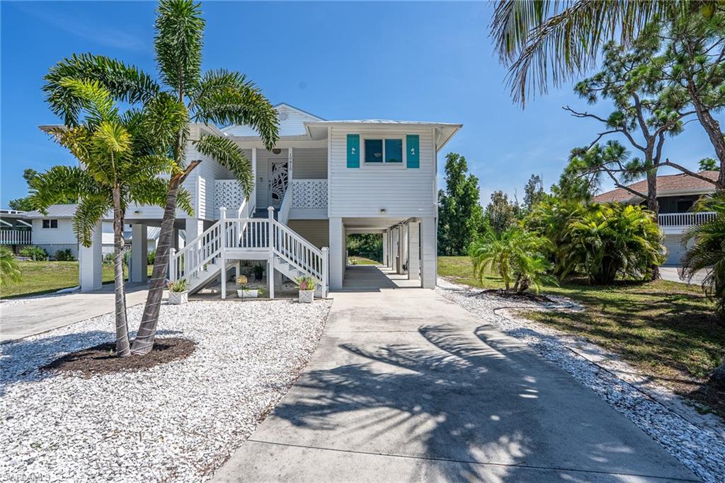 Motivated Seller and will Entertain Offers! Amazing Opportunity. Newly Renovated, Gorgeous Island Style Stilt Home! Three Bedrooms, Two Full Baths, with a Split Floor Plan and on .49 Acres of Land! Now Available in the Desirable “The Nesting of Pine Island” Neighborhood. Welcoming Dual Entry Staircase, Lovely Open Front Porch and the Charming Entry Foyer Await Your Arrival. Enter the Bright, Large Living Room with French Doors that lead out to a Beautiful Screened Porch, Huge Open Deck and Spiral Staircase with Views of the Sprawling Back Yard! Gorgeous Large Kitchen with Custom Breakfast Bar, All New Cabinetry with Pull Out Drawers, Quartz Countertops, Glass Tile Back Splashes including the Breakfast Bar, Under Cabinet Lighting, Recess and Pendant Lighting, Tons of Counter Space, All Stainless Appliances, and a Pantry with Built in Cabinetry and the Full Size Stackable Washer and Dryer. This Open Kitchen is Adjacent to the Bright, Over Sized Gathering Dining Room. Nice Main Bedroom with Walk In Sized Closet and an En Suite Bathroom with Glass Door Shower, Stone Floor and a Separate Sink Area. Guest Bedrooms with Access to Full Guest Bath with Glass Shower Doors. Outstanding Space for up to Ten Vehicles with Two Long Driveways hosting approx. Four Under the Two Large Carports, and/or RV, Boats, Trailers etc.  Fantastic Large Under House Storage Room and/or Workshop for all of your Hobbies or Storage Needs. The Open Balcony with New Deck Overlooks the Large Fabulous Back Yard. Nearly a Half Acre of Land with Plenty of Room for a Pool or Your Perfect Vision! Central Water. Private Septic. Recent Updates Throughout Including: Luxury Vinyl Flooring Throughout, All New Fixtures, Fans, Blinds and Appliances. Total New Kitchen 2022/2023 and Pantry with New Built in Cabinetry, New HVAC 2021, Remodeled Bathrooms with New Showers and Toilets, 2023/2024. New Metal Roof, All New Hurricane Impact Windows and Front Door. New French Doors. New Tankless Water Heater 2024/2025. New Screen Enclosed Porch and New Decking on the Back Open Balcony 2024. New Decorative Shutters 2024. New Front Deck Railings 2025. Updated Spiral Staircase. Dates are approximates. Located is a Beautiful Lush and Tropical Neighborhood Setting located at the center of Pine Island only minutes to the Community Pool, Museum, Playground, Baseball Fields, Library, Shopping, Specialty Shops, Restaurants and a Short Drive to Pineland Marina and our Local Ferries. Move In Ready! This Special Island Home is Simply a Must See!