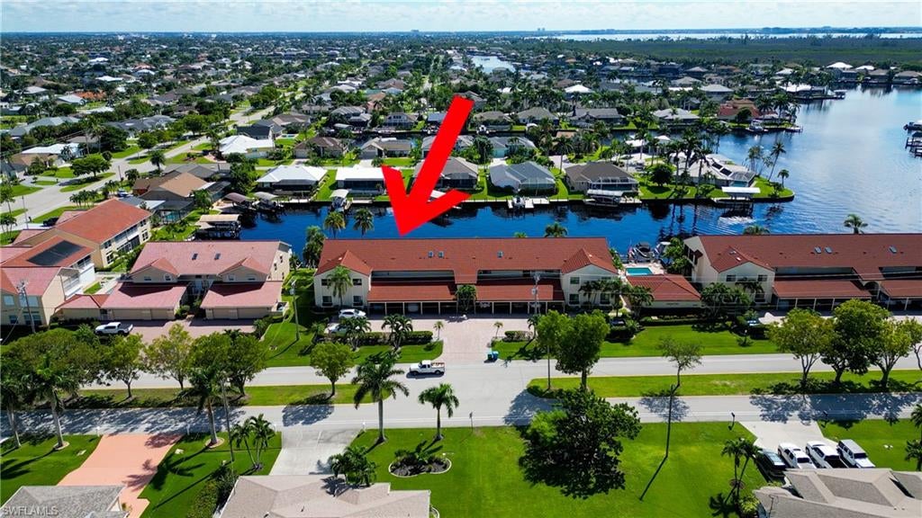 From dawn to dusk, THIS WATERFRONT living carries a TIMELESS CALM—mornings begin with sunrises and coffee on the lanai, afternoons drift by with a book you can’t put down, and evenings bring a cocktail before a leisurely cruise to dinner by boat. Life at Capstan Condos is all about the waterfront lifestyle on a stunning 200’ WIDE CANAL. Open the door to this spacious two-bedroom, two-bath retreat with covered parking and you’ll immediately notice what sets it apart. Soaring VOLUME CEILINGS and oversized windows flood the home with golden light, creating an airy, welcoming atmosphere that feels both grand and inviting. This isn’t your typical condo—it was BUILT AHEADS OF ITS TIME, with a UNIQUE DESIGN that makes the kitchen the heart of the home while still giving privacy to both the guest suite and the master retreat. The kitchen is tastefully designed with 36” wood cabinets accented by glass doors, crown and rope molding, soft close pull out drawers, granite counters, backsplash and pantry. Entertain with ease as the pass-through opens to the lanai, so you never miss the conversation—or the view. The greatroom flows effortlessly to the oversized lanai, where pocketing sliders dissolve the boundary between indoors and out. The master suite is a peaceful retreat on the water, complete with walk-in closet and a spacious bath featuring dual granite vanities with soft-close features. Guests enjoy their own private space on the opposite side of the home, ensuring comfort and privacy. This condo comes with its own ASSIGNED BOAT DOCK AND 6K LB LIFT (and new dock boards) perched on the 200’ wide Bronco Canal just around the corner from TARPON POINT and CAPE HARBOR. With only one bridge out, you’ll be enjoying the Gulf of America in no time at all. Imagine days spent cruising to Sanibel and Captiva, stopping for lunch at waterfront restaurants, fishing off your dock or simply enjoying the sight of dolphins and manatee playing in your backyard. Dinner by boat isn’t just possible—it’s YOUR NEW NORMAL. Peace of mind comes standard here!. The building has a BRAND-NEW ROOF, storm-ready doors and windows with a mix of ELECTRIC AND MANUAL ROLL DOWN SHUTTERS. NO water intrusion with any storm. Flood insurance won’t keep you up at night, with a TRANSFERABLE POLICY at just $734/year (subject to insurance co. approval). Capstan is a 55+ community known for its BEAUTIFULLY MAINTAINED GROUNDS AND WELCOMING ATMOSPHERE. Residents enjoy a heated saltwater pool, clubhouse, BBQ area, fish cleaning station, exterior storage, covered carports and pavered parking lot. Tucked among million-dollar waterfront homes, the location is as desirable as it is convenient—close to shopping, dining, marinas and just minutes out to the Caloosahatchee River & beyond. This isn’t just a condo, it’s your well-earned escape—sun-drenched mornings, barefoot boating afternoons and evenings where neighbors become friends and every sunrise feels like a celebration. SUNRISE TO SUNSET, PURE PARADISE!