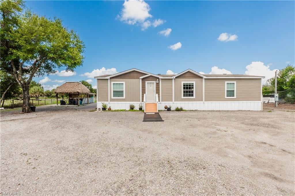 AMAZING OPPORTUNITY to own this BEAUTIFUL 2020 DOUBLE-WIDE MANUFACTURED HOME in MONTURA RANCH! Situated on a PRIVATE, FULLY FENCED 1.25-ACRE LOT.
The home features 1,456 SQ FT OF LIVING AREA with 3 BEDROOMS, 2 BATHROOMS. The BRIGHT and OPEN FLOOR PLAN includes a SPACIOUS FAMILY ROOM and DINING AREA, complemented by LARGE WINDOWS that fill the home with NATURAL LIGHT. 
The MODERN KITCHEN features a CENTER ISLAND and ample cabinet space. The CONTEMPORARY SLIDING BARN DOORS maximize space. The OVERSIZED LAUNDRY ROOM includes an ADDITIONAL COUNTER for extra workspace and storage. The SPACIOUS PRIMARY SUITE offers a LARGE EN-SUITE BATHROOM with DUAL SINKS, a SOAKING TUB, and a SEPARATE SHOWER. A REAR ACCESS RAMP provides convenient WHEELCHAIR ACCESS from the back door to the backyard, adding comfort and accessibility.

The EXTERIOR has been thoughtfully designed for both ENJOYMENT and FUNCTIONALITY. A WIDE DRIVEWAY across the front of the home provides AMPLE PARKING for multiple vehicles. The FULLY FENCED PROPERTY includes SEPARATE FENCED AREAS for different types of ANIMALS, making it ideal for those seeking a RURAL LIFESTYLE. A LARGE TIKI HUT WITH CERAMIC TILE FLOORING creates the perfect space for OUTDOOR ENTERTAINING, FAMILY GATHERINGS, BBQS, and RELAXING. The property also features TWO STORAGE CONTAINERS and an OPEN METAL ROOF STRUCTURE, offering additional space for EQUIPMENT, TOOLS, HOBBIES, or ADDITIONAL STORAGE. Located in the peaceful community of MONTURA RANCH ESTATES in HENDRY COUNTY, between CLEWISTON and LABELLE, this property combines the tranquility of COUNTRY LIVING with convenient access to SOUTH FLORIDA'S major cities. This is an EXCEPTIONAL OPPORTUNITY for anyone looking for ROOM TO ENJOY THE OUTDOORS.