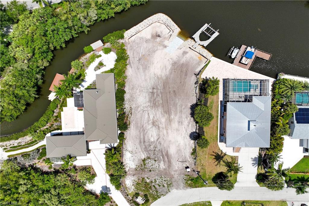 An extraordinary waterfront homesite offering a rare blend of scale, privacy, and direct Gulf access through Estero Bay. Set on nearly half an acre with approximately 123 feet of shoreline, this cleared property is a once-in-a-generation opportunity for the discerning buyer seeking an exceptional coastal lifestyle. A brand-new private concrete boat ramp with 32 feet of out-of-water, a new dock with 10,000-pound Neptune boat lift, and newly installed rip rap create a remarkable foundation for effortless boating and waterfront living—just 5 minutes from the Gulf.
City water and sewer, with temporary power and active water service, allowing you to move from vision to execution with ease. Tucked near the end of a peaceful cul-de-sac, the setting offers a quiet sense of seclusion, with minimal direct rear neighbors and a backdrop that feels private and serene.  Fast response to all offers.
For those that need expediency in building  a signature residence, existing plans for a two-story home with five bedrooms, five baths, and a dedicated office are available for the buyer to use as-is or tailor with their own builder. With much of the groundwork already completed—including a soil test indicating no pilings required for the current plans—this is a rare chance to design and build a custom waterfront retreat surrounded by the beauty of Southwest Florida nature.