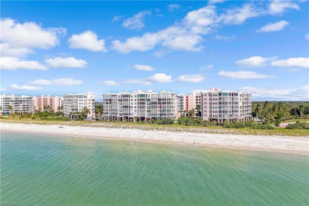 If your goal is to have toes in the sand without lifting a finger, this is the beachfront condo for you! This truly move-in-ready, furnished condominium captures the essence of sophisticated coastal living with breathtaking Gulf views and direct access to one of Southwest Florida's most beautiful stretches of shoreline.

The open-concept interior welcomes you with wide-plank flooring, coastal-inspired finishes, shiplap accents, and contemporary lighting. The beautifully appointed kitchen features crisp white cabinetry, luxurious sleek countertops, stainless steel appliances, a farmhouse-style sink, and two barstool seating areas, including an oversized island complemented by distinctive pendant lighting and a decorative wood-accented ceiling. The adjoining living and dining areas flow seamlessly toward the screened lanai, where panoramic Gulf views and unforgettable sunsets provide a spectacular backdrop for everyday living and entertaining.

The spacious primary suite offers captivating water views and direct access to the lanai, creating a private sanctuary overlooking the Gulf. Additional highlights include updated bathroom finishes, custom mirrors, generous storage, electric storm shutters, in-residence laundry, and under-building garage parking.

Beyond the residence, Barefoot Beach Club offers an exceptional collection of amenities, including direct beach access, a resident clubhouse with a fitness center, a resort-style swimming pool, and beautifully maintained tropical grounds. The gated community features staffed security, winding brick-paver streets, and a spectacular beachfront setting surrounded by the natural beauty of Southwest Florida's coastline. Optional membership at The Club at Barefoot Beach provides access to additional amenities, including casual and fine dining, tennis, beachside food and beverage service, and organized social activities.

Ideally situated in Collier County, Barefoot Beach offers convenient access to Barefoot Beach Preserve, where pristine coastal habitats, nature trails, and native wildlife create opportunities to experience Florida's natural beauty. Just a short drive away, enjoy waterfront dining along Bonita Beach Road, upscale shopping and entertainment at Mercato, the boutiques and restaurants of Waterside Shops, and the vibrant dining destinations of Naples and Bonita Springs. Southwest Florida International Airport is also conveniently accessible.

Whether enjoying morning coffee overlooking the Gulf, spending an afternoon on the sugar-white sand, or watching the sun disappear into the horizon from your screened lanai, this exceptional beachfront residence offers an extraordinary opportunity to experience the very best of Southwest Florida coastal living.