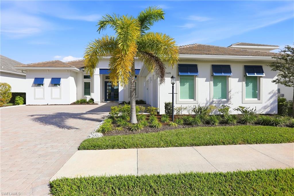 Welcome to your coastal sanctuary in the prestigious Esplanade Lake Club of Fort Myers. Presenting the highly sought-after Beacon floorplan, this move-in-ready residence offers an exceptional blend of architectural elegance and functional luxury, spanning over 3,300 square feet.

An impressive entrance with double French doors opens to a light-filled interior finished with sleek plank tile flooring throughout—no carpet in sight. At the heart of the home, the grand great room features a professionally designed white beadboard accent wall. The open-concept layout flows into an inviting dining area highlighted by a rich, dark blue wood-design feature wall.

Designed for the culinary enthusiast, the chef-inspired kitchen boasts white cabinetry, quartz countertops, a subway tile backsplash, a dedicated wine refrigerator, and premium appliances, including a gas cooktop, double oven, and built-in microwave.

The private master suite serves as a serene retreat. Its en-suite bath features dual sinks, a Zen-inspired custom accent wall, and an oversized walk-in shower with dual showerheads. The main living quarters are completed by two additional spacious bedrooms, two full bathrooms, a powder room, and a versatile den enclosed by privacy glass doors.

Built with peace of mind in mind, the home features impact-rated windows and sliders (with shutters for the mitered window), upgraded impact garage doors, dual A/C units, and spray-foam insulation for exceptional energy efficiency and quiet living.

Outside, an expansive covered lanai leads to a heated pool and spa, ideal for year-round outdoor entertaining. Located just a short stroll from Esplanade Lake Club’s world-class resort amenities, this home delivers the ultimate Florida coastal lifestyle.