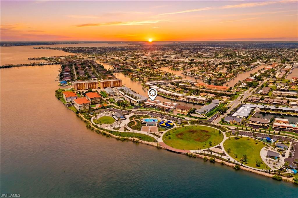 SECOND-FLOOR WATERFRONT CONDO with DIRECT GULF ACCESS & STUNNING WIDE CANAL VIEWS in SE Cape Coral! Located directly across from the exciting JAYCEE PARK in the highly desirable BEACH PARKWAY PROMENADE area, this BEAUTIFULLY FURNISHED 2-BEDROOM, 2-BATHROOM condo offers the perfect combination of SWFL lifestyle, boating access & long-term value. Jaycee Park’s incredible transformation with its scenic boardwalk, amphitheater, splash pad, boat dock, picnic areas & enhanced waterfront recreation; adds tremendous appeal to the neighborhood and makes this not only a WONDERFUL PLACE TO LIVE, but also a SMART INVESTMENT with STRONG EQUITY GROWTH POTENTIAL. WELCOME TO YOUR DREAM RETREAT IN SUNNY SOUTHWEST FLORIDA! This SECOND-FLOOR UNIT offers PEACE OF MIND w/ NO ONE ABOVE, NO FLOOD WORRIES & PRIVATE ENTRANCE, while showcasing PANORAMIC VIEWS of the 200+ FT WIDE NAVARRO CANAL and breathtaking SWFL SUNSETS! Enjoy your morning coffee from the PRIVATE SCREENED BALCONY or relax in the ENCLOSED SUNROOM while taking in refreshing breezes from the nearby CALOOSAHATCHEE RIVER & watching boats cruise by :) Boating enthusiasts will love DIRECT SAILBOAT ACCESS w/ just one turn to the RIVER & straight out to the GULF! Residents can unwind by CRYSTAL-CLEAR COMMUNITY POOL or enjoy the scenic, walkable surroundings of this BEAUTIFUL WATERFRONT COMMUNITY. Inside, the condo features an OPEN AND AIRY FLOOR PLAN with a tasteful blend of tile and carpet flooring, a spacious kitchen with seating area, and a flexible dining space perfect for formal dining or a cozy breakfast nook. The generous living room is filled with natural light and CAPTIVATING WATER VIEWS, making it ideal for entertaining or peaceful evenings at home! The SPACIOUS PRIMARY SUITE features a WALK-IN CLOSET, private bathroom with stand-up shower, makeup vanity and cabinetry, plus direct access to the SCREENED BALCONY overlooking the wide canal. The GUEST BEDROOM is generously sized and versatile, perfect as a second bedroom, home office, or both. A full-sized washer and dryer are conveniently tucked inside the unit. This 55+ COMMUNITY offers peaceful waterfront living with OPTIONAL DOCKAGE CURRENTLY UNDER CONSTRUCTION, ALL ASSESSMENTS PAID, and first-come, first-served availability; an excellent opportunity for boaters. The seawall is currently being repaired and is expected to be functional by Fall 2026. Additional highlights include MANUAL HURRICANE SHUTTERS for added protection, NEUTRAL INTERIOR COLORS, A/C (2018), WATER HEATER (2017), MOVE-IN READY condition, and NO PETS ALLOWED. Ideally located near Cape Coral’s vibrant dining, shopping, and entertainment, and just a drive away from some of SOUTHWEST FLORIDA’S BEST BEACHES including Fort Myers Beach, Sanibel, Naples, and Marco Island. This is your opportunity to own a BEAUTIFUL WATERFRONT CONDO with DIRECT GULF ACCESS in one of SE Cape Coral’s most sought-after neighborhoods :) MOVE IN AND START ENJOYING THE FLORIDA LIFESTYLE TODAY! LOVE WHERE YOU LIVE!