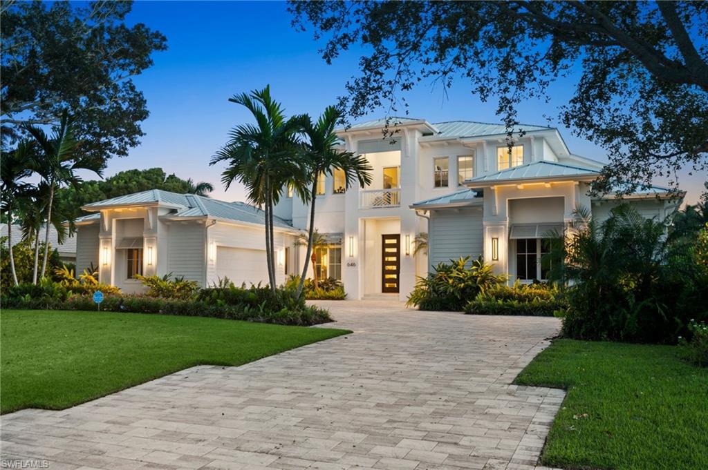Located in the sought-after Moorings neighborhood, this newly built two-story residence offers a blend of classic design, comfortable living, and inviting indoor-outdoor spaces. Southern exposure fills the property with natural light, while tropical landscaping provides privacy. Offered fully furnished, the home features Legno Bastone oak flooring, custom millwork, elegant wall and ceiling details, and two fireplaces that add warmth and character. The kitchen is designed for everyday living and entertaining, with professional-grade Sub-Zero and Wolf appliances, custom cabinetry, and a walk-in pantry. Built by Dillman Construction, the home features a thoughtfully designed floor plan with a first-floor primary suite and spa-inspired marble bath, a main-level guest suite, and two additional upstairs bedroom suites. The oversized upstairs loft is perfect for a kids’ hangout, game room, or additional living space. Other features include a private office with built-ins, elevator, Lutron lighting, Halo whole-house water filtration system, whole-house generator, and two separate two-car garages. Outdoor living takes center stage with a 41-foot lap pool, cascading waterfall, spa, and fire features. The covered outdoor entertaining area includes a fully equipped kitchen, comfortable lounge space with fireplace, and electric screens and shutters, creating an ideal setting for relaxing or hosting guests. Completely surrounded by lush tropical landscaping, the pool and outdoor living areas lives like a private retreat. Conveniently located just minutes from Venetian Village and downtown Naples shopping and dining, the home also offers access to the private Moorings beach, making it easy to enjoy the best of coastal Naples living.