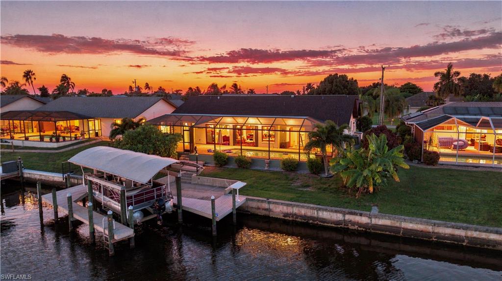 DIRECT GULF ACCESS pool home and NO FLOODING from past hurricanes! There are no bridges so it's great for sailboats too, only one turn and you're out to the river. Centrally located to all Cape Coral has to offer and easy access to Fort Myers. NO CARPET in this newly tiled 3 bedroom home with pool bath and remodeled master bath. Great room with vaulted ceilings, formal dining area and recessed den that can be used as an office or workout room. This home is being offered FURNISHED, NEW AC in 2021, NEW ROOF in 2018, NEW exterior paint 2026, and ALL ASSESSMENTS PAID. There are TWO covered lanais with outdoor kitchen and full size refrigerator. There are lots of slider doors to lead out to the beautiful pool area with tanning shelf, multi colored LED light, waterfall, and NEW pool heater. Walk down to your private, newly resurfaced boat dock with a 10,000 lb. lift, NEW canopy cover, and water and electric. You can feel secure with hurricane impact windows, accordion hurricane shutters for the lanais, and current flood insurance policy is transferable to the new owners. SECURITY CAMERAS stay with the home. Schedule your showing today!