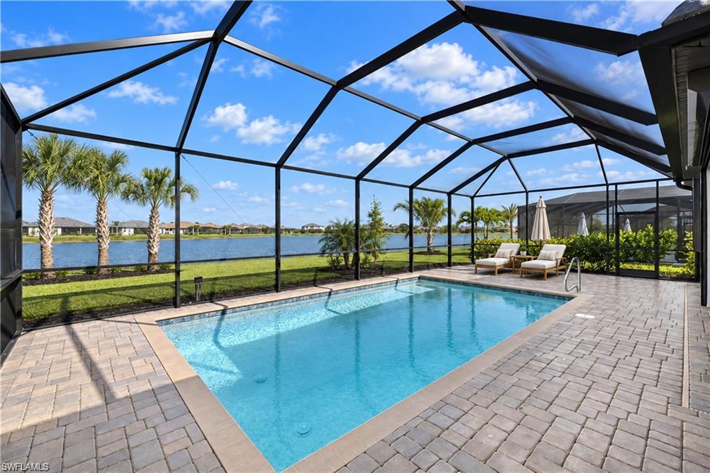 One or more photo(s) has been virtually staged, AI generated or rendered.  SPECTACULAR LAKE VIEWS, BEAUTIFUL SUMMER SUNSETS, AND RESORT LIVING await in this beautifully appointed SUMMERVILLE POOL HOME at THE PLACE AT CORKSCREW. Fresh, bright, and inviting, this residence offers 3 BEDROOMS PLUS A DEN, 3 FULL BATHROOMS, a 3-CAR GARAGE, and approximately 2,445 square feet of designed living space. The OPEN CONCEPT layout showcases WHITE CABINETRY, GRANITE COUNTERTOPS, CROWN MOLDING, and 12-by-24-inch TILE throughout the main living areas. A generous kitchen island creates a gathering space, complemented by a CUSTOM PANTRY, pull-out drawers, and kitchen reverse osmosis. Step outside to your SCREENED LANAI AND PRIVATE HEATED POOL, where expansive water views and NORTHWEST REAR EXPOSURE create a backdrop for relaxing afternoons and summer sunset entertaining. Upgrades include a WHOLE-HOUSE KOHLER GENERATOR WITH PROPANE TANK, HURRICANE SCREENS at the lanai and front entry, ACCORDION SHUTTERS, custom primary bedroom closets, and surge protection. Enjoy RESORT-STYLE AMENITIES including a pool with a 100-FOOT WATERSLIDE, community spa, restaurant, BOURBON BAR, café, outdoor bar, FITNESS CENTER, TENNIS, PICKLEBALL, bocce, basketball, playground, and dog park. TWO STAFFED GATED ENTRANCES and a nearby PUBLIX complete the lifestyle. Discover elegant interiors, captivating lake views, and exceptional amenities in a home that makes every day feel like a getaway.