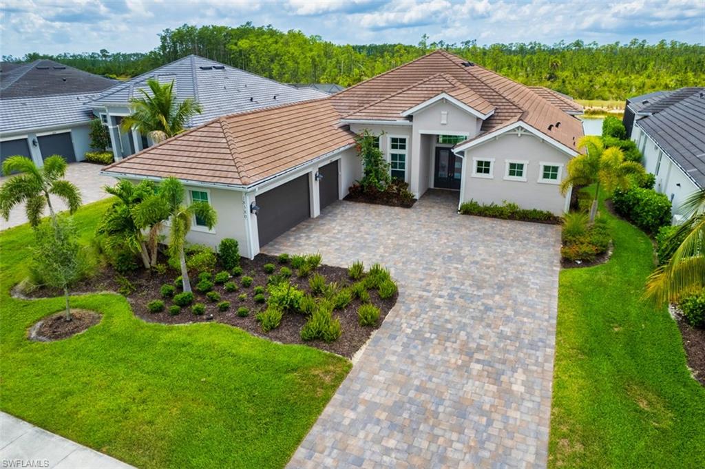 Welcome to 18380 Wildblue Blvd., an exceptional lakefront residence in Fort Myers’ premier luxury community. This stunning WCI-built Iris model combines sophisticated design, refined finishes, and effortless indoor-outdoor living on a pristine waterfront homesite.  The open-concept interior features soaring ceilings, abundant natural light, and wood-look tile flooring. At the heart of the home, the spacious great room flows seamlessly into a gourmet kitchen with premium appliances, quartz countertops, custom cabinetry, and a generous walk-in pantry. The luxurious owner’s suite offers a spa-inspired bath with dual vanities, a soaking tub, and an oversized walk-in shower. Two of the three guest suites feature private ensuite baths, providing comfort and privacy for family and visitors.  Pocketing sliding doors open to an expansive lanai overlooking tranquil lake views, where a heated saltwater pool and spa, fully equipped summer kitchen, and spacious covered outdoor living area create the perfect setting for entertaining or relaxing. Additional highlights include hurricane-impact glass throughout and a three-car garage with epoxy flooring.  WildBlue residents enjoy an outstanding resort-style lifestyle with a private lake for boating and kayaking, a state-of-the-art fitness center, tennis and pickleball courts, clubhouse dining, and miles of scenic walking and biking trails. Conveniently located near Southwest Florida International Airport, shopping, fine dining, golf, and area beaches, this remarkable lakefront home offers the best of luxury Florida living.