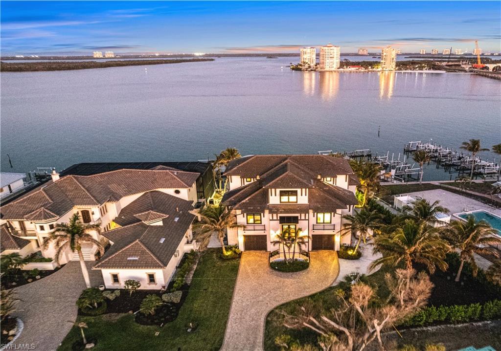 Exceptional 2019-built masterpiece on the coveted South end of Estero Island. Offering some of the most expansive and breathtaking bay views the island has to offer, this residence is the epitome of coastal luxury living. A haven for boating enthusiasts, it boasts direct access to the Gulf with just a two-minute boat ride. The property features a private dock, a 12,000 lb boat lift that previously accommodated a 40-foot boat, and a jet ski lift. Located just a 7-minute (0.3-mile) stroll from deeded beach access exclusive to a limited number of South end bayside residents, this home is perfectly positioned for both beach and boat lovers. No details were overlooked while meticulously crafting this architectural marvel, from beautiful oak flooring to inverted tray ceilings with custom lighting. Inside, the expansive open layout includes 4 spacious bedrooms, 4 full bathrooms, 2 half-baths, dual laundries, and a garage that has ample space for 6+ cars. Step outside to your own backyard oasis, where an expansive pool deck awaits, featuring an elevated pool with a sun shelf, spa, a fireplace, a summer kitchen, a pool bath, and a bar area with swinging chairs and seating – perfect for entertaining or relaxing. The gourmet chef’s kitchen is equipped with high-end granite waterfall countertops, sleek white cabinetry, premium Jenn-Air appliances, and a butler’s pantry. The luxurious primary suite offers sweeping Bay views, a private lanai, dual walk-in closets, and a spa-like bathroom with dual vanities, a freestanding tub, and a shower with multiple shower heads for ultimate relaxation. Additional features include a whole-house filtration system, a 500 lb buried propane tank, a private elevator, hurricane impact windows and sliders, electric storm shutters, interior electric screens, a Lutron lighting system, and a surround sound system. Prime location on a peaceful stretch of South Estero Island close to many fantastic restaurants and easy access to Lovers Key/Bonita Beach. This is the pinnacle of waterfront living.