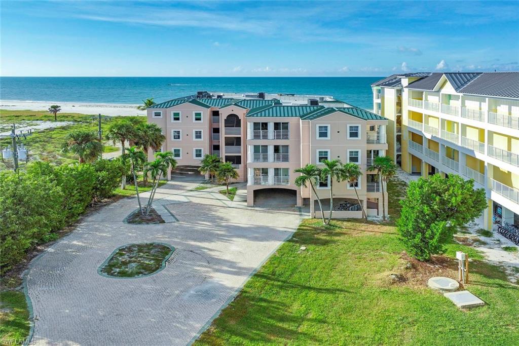 Wake up to the Gulf of Mexico and end each day with Sanibel’s famous sunsets from this spacious, beautifully remodeled residence at Lantana, an intimate complex of just six private condos directly on the beach along West Gulf Drive. With approximately 3,400 total square feet, this is anything but a typical condo. Featuring 4 bedrooms, 3 and 1/2 baths, it lives like a single-family home, with an open, flowing layout designed for both relaxed island living and effortless entertaining.
A gracious entryway, with an elevator just outside your front door, welcomes you into a light-filled living area that flows seamlessly into the dining room and kitchen, with beautiful gulf view and swaying palm trees. The living room opens to an expansive lanai that adapts to the season: leave it screened to enjoy the island breezes, or close the sliders to create a glass-enclosed extension of your living space. Rich wood flooring runs throughout, and the fully renovated kitchen is finished with white cabinetry, quartz countertops and high-end appliances.

The primary suite is a true retreat, with its own sunset views, a large ensuite bath featuring a soaking tub and separate shower, generous closet space and built-in drawers. Step from the bath out to the lanai and down to the pool, or head straight to the sand for an evening stroll or a morning of shelling.

Thoughtfully designed for privacy, the three guest bedrooms and their baths sit on the opposite side of the home from the primary suite and living areas, and each has its own private balcony, so family and friends have a peaceful space of their own. A large laundry room and a private storage closet in the garage add everyday convenience.

Call today to schedule your showing!