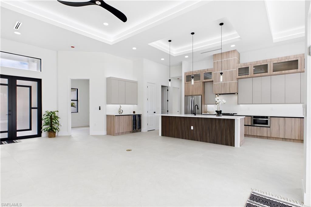 MOVE-IN READY 2026 COASTAL CONTEMPORARY NEW CONSTRUCTION! Enjoy SOUTHERN REAR EXPOSURE for ALL-DAY SUNSHINE, 2-10 HOME WARRANTY, NO FLOOD INSURANCE REQUIRED, NO HOA! Modern new construction designed for effortless SWFL living! Located in SW Cape Coral, durable METAL ROOF & 3-CAR GARAGE! $1,800-$2,400/year homeowners' insurance! Enjoy easy access to CHIQUITA BLVD, BURNT STORE RD & PINE ISLAND RD, your commuting & daily errands easier! This CONTEMPORARY LUXURY HOME features SCREENED, HEATED POOL & SPA & 4 BEDS (2 primary suites) & 3 full BATHS, layout ideal for EVERYDAY LIVING & ENTERTAINING! SCREENED LANAI w/ PERFECT SETTING TO RELAX in SPA, SWIM in HEATED POOL, or HOST UNFORGETTABLE BBQs! Bright, open layout w/ LIGHT NEUTRAL TILE FLOORING. IMPACT-RESISTANT DOUBLE DOORS lead into WELCOMING LIVING ROOM w/ 14-ft VOLUME CEILING & SLIDING DOORS TO LANAI. GORGEOUS CHEF’S KITCHEN w/ sophisticated CUSTOM CABINETRY w/ warm NATURAL WOOD-GRAIN base cabinetry paired w/ elegant LIGHT GREIGE FLAT-PANEL UPPER CABINETS. Rich EUROPEAN OAK-INSPIRED wood texture adds warmth & dimension. Crisp QUARTZ COUNTERTOPS & FULL-HEIGHT QUARTZ BACKSPLASH w/ clean modern palette, while UNDER-CABINET LED LIGHTING enhances bright, open ambiance. Equipped w/ SS appliances, French-door refrigerator, microwave, smooth-top range, cabinetry covered HOOD & dishwasher. Oversized WATERFALL ISLAND w/ striking vertical WOOD SLAT DETAILING, abundant storage & minimalist HARDWARE-FREE CABINETRY. Built-in BUTLER’S PANTRY showcases matching WOOD-GRAIN BASE CABINETRY, sleek LIGHT GREIGE UPPER CABINETS, QUARTZ countertops, under-cabinet lighting & built-in WINE REFRIGERATOR, creating the perfect BEVERAGE STATION, COFFEE BAR, or EXTRA STORAGE & PREP SPACE. DINING ROOM features soaring volume ceiling, recessed LED lighting & LARGE PICTURE WINDOW to screened lanai, pool/spa & covered patio/outdoor kitchen. LARGE PRIMARY SUITE w/ sliding doors to lanai, WALK-IN CLOSET w/ BUILT-IN SHELVING & HANGING RACKS & LUXURIOUS PRIMARY BATHROOM w/ spacious WALK-IN GLASS SHOWER w/ floor-to-ceiling designer tile, rainfall showerhead, built-in bench & modern matte-black fixtures. Dual sink vanity w/ quartz countertops, sleek white cabinetry & contemporary lighting complements the spa-like design. Private water closet & natural light create BRIGHT & SERENE RETREAT! BUILT-IN CUSTOM CLOSET WARM WALNUT-TONE WOOD CABINETRY for ADDED STORAGE & CLEAN, UPSCALE LOOK. SPLIT LAYOUT w/ SECOND PRIMARY SUITE w/ POOL BATHROOM & TWO GUEST BEDROOMS w/ HALL BATHROOM for added privacy. Step outside to SCREENED LANAI w/ HEATED POOL & SPA, landscape & FULLY EQUIPED OUTDOOR KITCHEN w/ BUILT-IN stainless steel BBQ GRILL, SINK, BEVERAGE REFRIGERATOR, GRANITE COUNTERTOPS & MODERN BACKSPLASH! PAVER FLOORING & CEILING FAN. FENCE YARD, LAUNDRY w/ laundry tub & custom cabinetry, 3-CAR GARAGE & METAL ROOF complete HOMES' FEATURES. YOUR SWFL LIFESTYLE AWAITS, RELAX, ENTERTAIN & ENJOY YEAR-ROUND SUNSHINE IN YOUR OWN PRIVATE POOL/SPA RETREAT!!!
