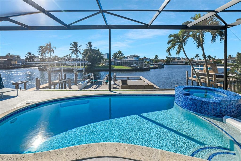 Luxurious Waterfront Retreat on Marco Island.

Escape to paradise in this stunning Marco Island home, where white sandy beaches meet unparalleled luxury. Boasting a private dock for entertaining, this waterfront gem is perfect for hosting unforgettable gatherings with family and friends. Step outside to your resort-style outdoor living oasis, featuring an outdoor kitchen and spacious lounge area ideal for al fresco dining, sunset cocktails, or simply unwinding in style.

Indulge in beautiful water views from nearly every angle, with direct access to the Gulf's shimmering waters right from your backyard. Cool off in the private heated pool and spa, surrounded by beautiful water views.

Conveniently located close to fine dining and shopping centers, yet just a walking distance to Marco's white sandy beaches, you'll enjoy the best of island living, pristine shores, upscale boutiques, and gourmet restaurants all within reach. Whether you're relaxing on your private dock, lounging poolside, or strolling the beach at dusk, this home offers the ultimate blend of relaxation and adventure on Marco Island