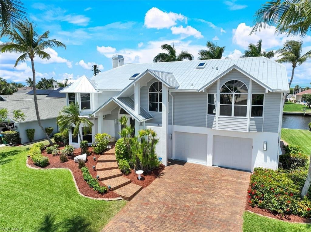 Exquisite Custom Key West Home with Deep Water Direct Access! Located next to the Tarpon Point area in SW Cape Coral, Unit 64. Discover your dream home in one of Cape Coral's most sought-after locations! This stunning custom-designed Key West residence boasts deep water direct access, perfect for accommodating larger boats. Key Features include panoramic views from the spacious upstairs living area, featuring impressive high cathedral ceilings and expansive windows that fill the space with natural light.The heart of the home showcases a beautiful updated Gourmet kitchen, equipped with a new commercial-sized refrigerator and modern appliances, ideal for entertaining.A real coral fireplace serves as a focal point in the living area, creating a warm and inviting atmosphere for gatherings with family and friends.The expansive primary bedroom offers stunning views of the pool and canal through large windows, providing a serene retreat. Step into a newly upgraded bathroom featuring a spacious walk-in shower with a top-of-the-line rain showerhead, a separate soaking tub, modern countertops, cabinets, and stylish lighting. The main living floor also includes a dedicated office/den space, perfect for remote work or study, along with a newly renovated powder room for guests. The outdoors is an Outside Oasis, overlooking  the wrap-around dock that features electric capabilities and an 8,000 lb boat lift, allowing for seamless boating experiences. There’s also substantial room for expansion, ensuring that your aquatic adventures can be maximized. The oversized pool, spa, and newer outdoor kitchen, along with a spacious lanai, create an amazing environment for entertaining guests and enjoying sunny Florida days. Downstairs, you'll find a billiard room, a full pool bathroom, and two guest bedrooms with a Jack and Jill bathroom, making it an ideal space for hosting family and friends.

This home is not just a residence but an entertainment paradise, making it one of the best homes for hosting in Cape Coral. Experience the ultimate waterfront lifestyle with direct access to the beautiful waterways and Gulf of America.
*Assumable Flood Insurance Policy less than $1.000 Annually, 9’ft Elevation.