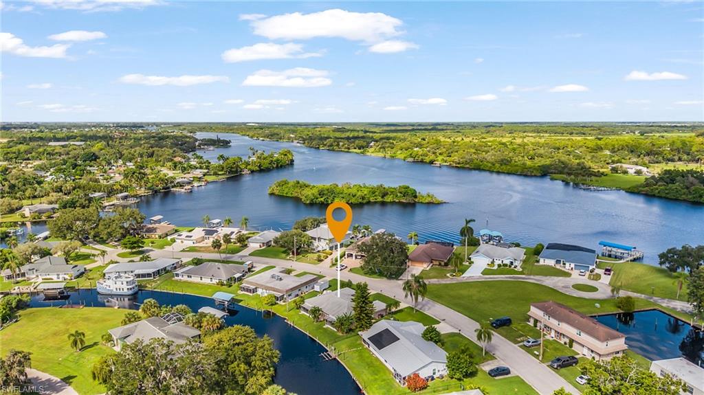 This is the kind of income property that almost never comes up. A well-maintained duplex on a deep-water canal with true sailboat access to the Caloosahatchee River and the Gulf of America — no bridges between you and open water. About five minutes by boat to the river, with lots of room for a boat dock. Both sides are identically laid out and look the same. Each offers approximately 977 square feet with 2 large bedrooms, 2 full baths, tile throughout, a spacious kitchen, a spacious 1-car garage with room to park an F-150 or GMC Sierra, and a screened lanai looking out over the canal. The right side is currently owner-occupied. The left side is a rental. Major updates are already behind you. A new roof, interior remodel, plumbing, and new impact windows and doors — including the front doors and garage doors — were completed in 2022. Both units have 2019 air conditioning. Make this your primary or seasonal home and collect income from the other side, or rent both units. Quiet Olga residential setting, across from newer riverfront homes, and convenient to Alva, I-75, Downtown Fort Myers, Babcock Ranch, and LaBelle.
Deep-water, no-bridge sailboat duplexes are exceptionally scarce in this part of town. A true unicorn for an owner-occupant or an investor who wants waterfront lifestyle and rental income in the same property.