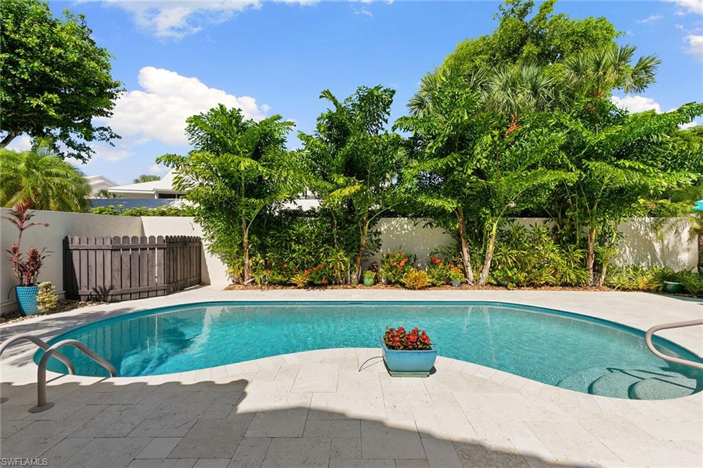 The privacy of a single-family home, the ease of a villa, and the Pelican Bay lifestyle at an approachable price. Welcome to Sand Pointe and a beautifully renovated, detached villa that lives much larger than its two-bedroom, two-bath floor plan suggests. Enjoy your private entrance, attached two-car garage, and a spacious, walled tropical courtyard with an oversized swimming pool and expansive travertine patio, ideal for outdoor dining, entertaining or relaxing in the Florida sunshine. Inside, the open floor plan features a beautifully updated kitchen with custom wood cabinetry, stainless steel appliances, and granite waterfall countertops overlooking the main living area. The primary suite offers a generous walk-in closet, an additional closet, dual vanities and a spacious walk-in shower, while the guest bedroom is privately on the opposite side of the home. A newer roof (2019), hurricane-impact windows and doors, and desirable X-500 flood zone location provide additional peace of mind for seasonal owners. Sand Pointe experienced no damage during recent storms, according to the owner, and offers a pet-friendly setting with low association fees. No shared lobbies, elevators or long hallways. Just the comfort of your own home with the convenience of a lock-and-leave lifestyle. Best of all, enjoy everything that makes Pelican Bay one of Naples favorite coastal communities, including private beach access, beachfront dining, beach attendants, fitness and wellness facilities, tennis, pickleball, and miles of recreational and biking paths. Waterside Shops, Artis Naples, and the restaurants of Mercato are just minutes away. For buyers seeking a manageable Naples retreat with a private pool, generous outdoor space, and easy access to the beach, 805 Sand Pointe offers a compelling alternative to condominium living.