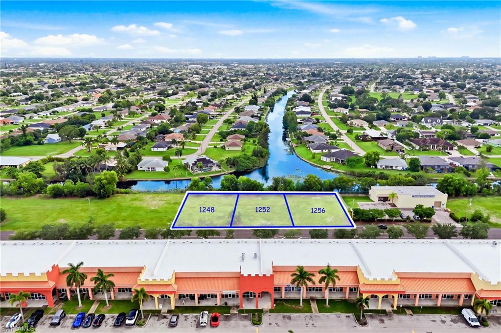PRIME COMMERCIAL DEVELOPMENT OPPORTUNITY – EXCELLENT POTENTIAL FOR INDUSTRIAL FLEX SPACE, AUTOMOTIVE BUSINESSES, AND OFFICE/WAREHOUSE CONCEPTS! Discover the possibilities of this three-lot commercial assemblage located at 1248, 1252, and 1256 SW 4th Street in Southwest Cape Coral! Offering approximately 30,056 square feet of land and an impressive 240 feet of road frontage, this property presents an
attractive opportunity for investors, developers, and business owners. Strategically positioned adjacent to Sherwin-Williams and just off the growing Pine Island Road corridor, the location provides convenient access to established businesses, shopping centers, and surrounding residential communities. Envision a modern industrial flex development featuring automotive garages with attached offices, contractor bays, workshops, or multi-tenant office/warehouse units. The property's generous dimensions offer flexibility for designing functional commercial spaces with overhead garage doors, private offices, and dedicated work or storage areas. Adding to its appeal, the property features canal frontage, creating a distinctive setting within Cape Coral's expanding commercial market. Whether you're considering an income-producing multi-tenant development or a customized facility for your own business operations, this location offers an opportunity to bring your commercial vision to life. THREE COMMERCIAL LOTS, 240 FEET OF ROAD FRONTAGE, AND EXCITING DEVELOPMENT POTENTIAL IN SOUTHWEST CAPE CORAL! All proposed uses are subject to zoning regulations, permitting, and approval by the City of Cape Coral. Buyer to independently verify property dimensions, permitted uses, utilities, assessments, flood zone designation, and development feasibility.