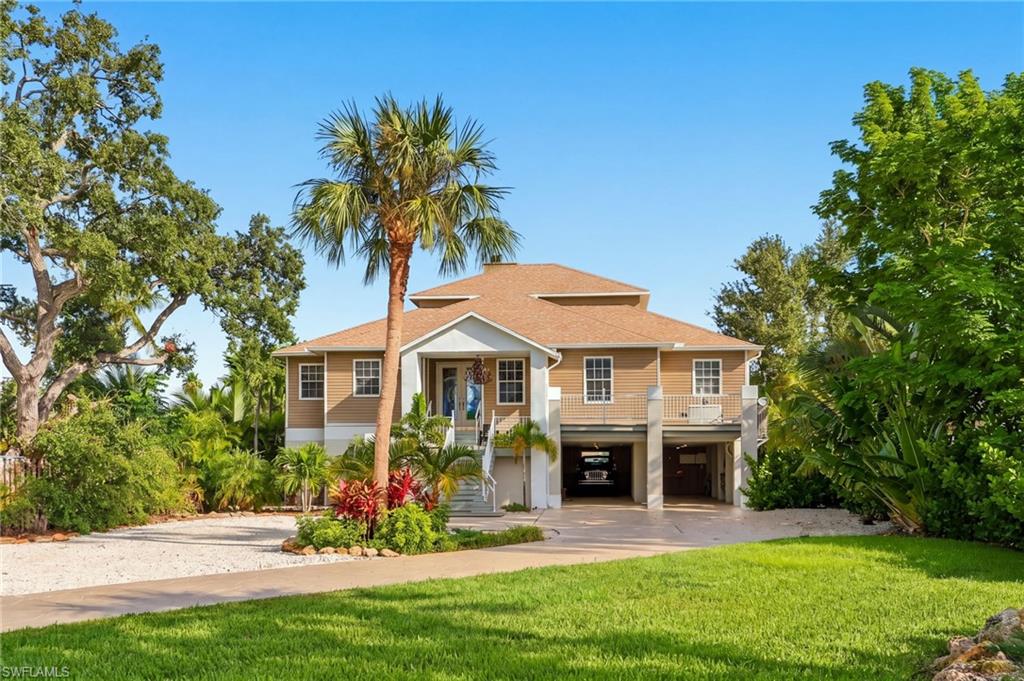 Some homes are simply places to live. Others make you slow down, take in your surroundings, and appreciate the beauty of where you are. Welcome to 211 Sterling Avenue, a waterfront home on Fort Myers Beach where thoughtful design, natural beauty, and the easy rhythm of island living come together.

Tucked along a peaceful canal on an oversized, landscaped lot of nearly half an acre, this property offers something rare on the island: room to breathe, privacy to unwind, and the freedom to enjoy both the water and the beach moments from your doorstep.

From quiet mornings watching the wildlife along the canal to afternoons spent boating or relaxing by the pool, life here is to be enjoyed. The expansive backyard is a private tropical escape, complete with a heated pool and spa, generous lounging areas, and a screened-in balcony overlooking the water. For boating enthusiasts, a private dock with a 10,000-pound boat lift and direct Gulf access makes spontaneous boating part of daily life.

Inside, the home has warmth and character. Soaring 21-foot ceilings welcome you into the great room, where natural light, beautiful wood-look flooring, and a wood-burning fireplace create an impressive, inviting space. The open layout was designed for gathering, whether it’s an intimate evening by the fire or a house full of friends and family sharing stories after a day at the beach.

At the heart of the home, the kitchen brings together function and personality with custom cabinetry, stainless steel appliances, and a professional-grade eight-burner gas stove. It’s a space made for cooking, entertaining, and the simple pleasure of being together. The primary suite offers its own peaceful retreat, complete with a private sitting area, generous closet space, and a spa-inspired bathroom featuring dual rainfall showerheads, a separate soaking tub, and dual vanities. Two additional bedrooms provide comfortable accommodations for family and guests, while the spacious upstairs loft offers flexibility for a home office, creative studio, or additional lounge. Throughout the property, thoughtful details reflect a home designed to be lived in and enjoyed. A whole-home generator, impact-resistant windows and doors, a newer roof reported as installed in 2020, generous storage, and space for a future private elevator add practicality to its coastal charm. And while the home feels wonderfully tucked away, the white sandy beaches of the Gulf are just a short walk away, with nearby restaurants, shopping, and the beloved island lifestyle all within easy reach. What makes 211 Sterling Avenue special isn’t just its size, its waterfront setting, or its many features. It’s the feeling of being here. The peaceful mornings, the salt air, the connection to nature, and the opportunity to create lasting memories in a place that encourages you to enjoy every moment. This is more than a waterfront home. It’s an invitation to experience Fort Myers Beach the way it was meant to be lived.