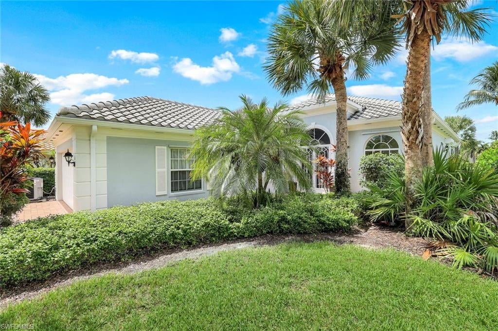 Lush and tropical landscaping surround this beautiful LAKEVIEW Divosta built 3 Bedroom 2 Bathroom+Den Oakmont Model Home WITH**NEWER ROOF 2023**that offers a screened in entry and Lanai for those days with cooler breezes. Start making your guest list because this home is perfect for entertaining. It features an upgraded Wood Flooring Throughout the home and Bright Open Kitchen that includes corian counters. NEWER A/C 2023 & ELECTRIC HURRICANE SHUTTERS at back of home. The flowing floor-plan provides generous living space, impressive 12 foot ceilings in the Great Room with Crown Molding and a separate room off the kitchen that can be used for a formal dining room or a den. Relax in your luxury master suite featuring a walk in closet and His and Her master bath. Gaze out over your SPECTACULAR LAKE AND SUNSETS then boast to your friends that your at home in IslandWalk. This is the life you dream of and IslandWalk offers the quality you insist on. DiVosta steel reinforced poured concrete construction and is located within easy walking or biking distance to all Island Walk TownCenter amenities. HDTV & High Speed Internet, Lawn & Landscape Care & Sprinklers are included in your LOW FEES and NO CDD make this Award Winning Community Town Center amenities with resort and lap pools, 7 har tru tennis courts, 4 pickleball courts, state of the art fitness center, putting green, bocce courts, post office, Fantastic Casa Cotzelli Restaurant, gas station, car wash, hair and nail salons. All this and just minutes to world class dining, shopping and amazing beaches. Make this your home in Paradise !! Come take a look and make this home your address in Paradise!