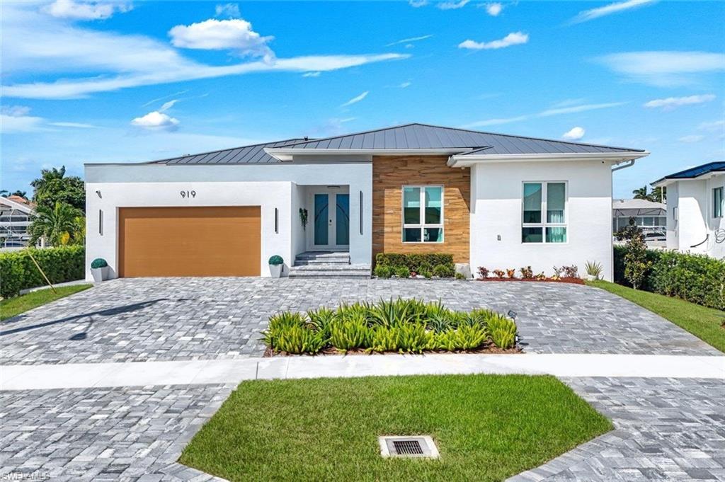 Welcome to 919 Juniper Ct, a newly built, custom contemporary waterfront home offered fully furnished on Marco Island. This residence of exclusive architectural design offers three bedrooms plus a den, and four full bathrooms ( with his and hers water closets ), pairing clean modern lines with bright, open living spaces and smart-home technology throughout. Every bedroom has its own bathroom, and a full bathroom off the pool deck serves outdoor guests. The kitchen features a full suite of Jenn-Air appliances, including a 42'' refrigerator. The primary suite offers electric blackout drapery, a safe, and a bathroom with a bidet, and each bedroom has an 11' closet. Quality shows in the construction: a metal roof, foam insulation throughout, cypress accents at the roofline and entry, 8' sliders, and good elevation. A building inspection by Cronin Engineering is also available to review. For peace of mind there's a Generac 26 kW whole-home generator with three transfer switches and a 10-year warranty, two 3-ton A/C systems with a 10-year warranty, zoned for the common areas and the bedrooms, a propane water heater with a recirculation pump, and a 500-gallon propane tank. The technology package includes Lutron lighting, Sonos sound in the family room and on the lanai, and motorized Somfy drapery integrated with a Bond hub, all controlled by app. You'll also find fiber-optic internet, Cat 6 wiring with six wireless access points, nine surveillance cameras, and an ADT alarm system. TVs are included in every room, among them an 85'' in the family room and a 75'' in the primary suite. Outside, enjoy the saltwater pool with AquaLink automation and an electric heater, along with premium outdoor furniture and both grills, including a Big Green Egg. The 1,500 sq ft dock and 14,000 lb boat lift sit on an indirect-access canal with a new seawall, a short cruise to the Marco River and the Gulf of America. The two-car garage adds two 400 lb storage lifts. Furnishings are available, so you can move right in and start enjoying island life. Spend your days on Marco Island's miles of white-sand beaches, then enjoy its waterfront restaurants, shopping, golf, and world-class boating and fishing, all just minutes from home. Schedule your private showing today.