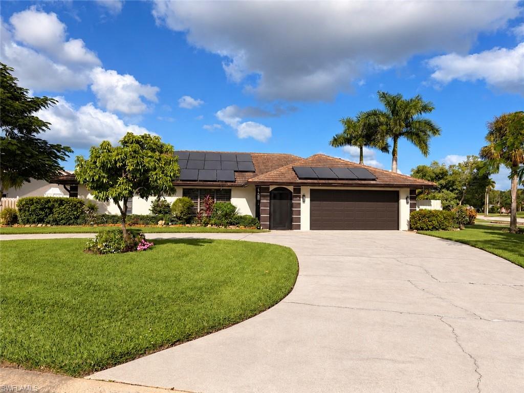 Welcome to 102 Muirfield Circle, a beautifully maintained 3-bedroom, 2-bathroom residence situated on a large corner lot in the highly desirable Lely Country Club Estates. Offering exceptional privacy, mature landscaping, and several fruit trees, this property combines comfort, style, and outdoor living in one of Naples' most established communities. The seller is highly motivated and is offering up to $10,000 toward the buyer's closing costs with a full-price offer, providing tremendous value and savings.  Designed with both functionality and comfort in mind, the home features a bright, open floor plan with vaulted ceilings that create a spacious and inviting atmosphere. The primary suite is thoughtfully separated from the guest bedrooms, providing additional privacy. Pocket sliding doors lead directly from the owner's suite to the lanai, while the en-suite bathroom offers dual vanities, a walk-in shower, a relaxing soaking tub, and a generously sized walk-in closet.

The fully renovated kitchen serves as the heart of the home and showcases quartz countertops, stainless steel appliances, modern cabinetry, a stylish tile backsplash, and abundant workspace. Elegant white luxury tile flooring extends throughout the home, creating a clean and contemporary feel.

Additional interior features include a formal dining area, an oversized laundry room, solar panels, and an updated guest bathroom with a new vanity and beautifully tiled shower surround.  Outdoor living is equally impressive. The expansive screened lanai offers multiple sliding door access points and includes a fully equipped outdoor kitchen with a built-in sink and stove, making it the perfect setting for entertaining family and friends. The oversized corner lot provides exceptional privacy and ample space to create your dream backyard oasis, with plenty of room for a custom swimming pool.  Conveniently located just minutes from Downtown Naples, world-renowned beaches, shopping, dining, and golf, this exceptional property offers the perfect blend of luxury, privacy, and Florida lifestyle living.