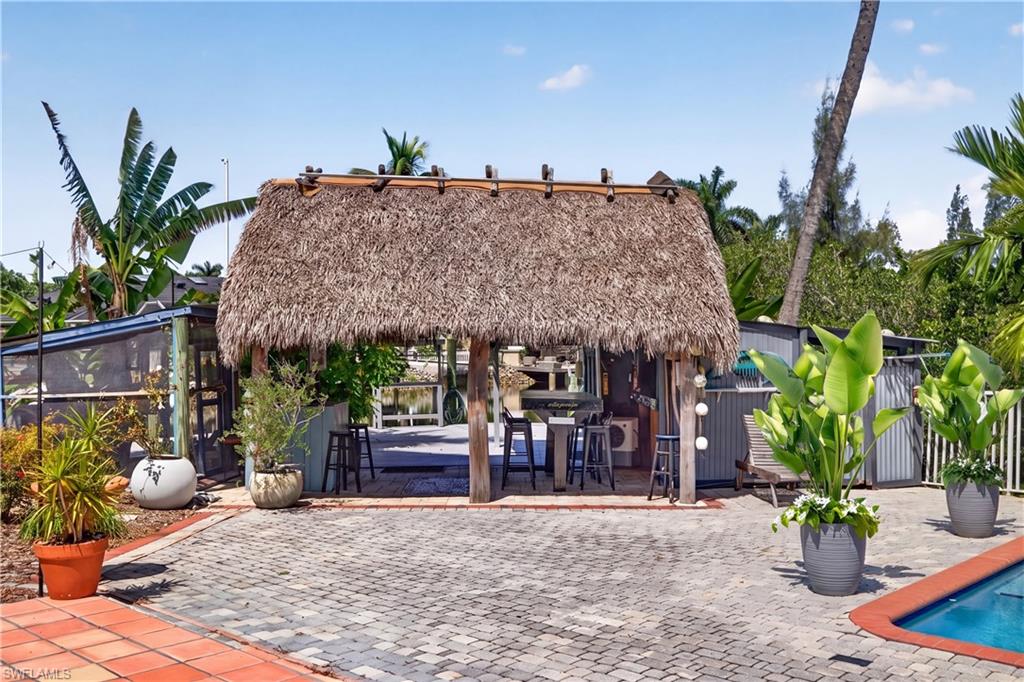 Discover your own secluded waterfront haven on this beautifully landscaped .68-acre Gulf-access property. With water on two sides, panoramic views, and a tranquil peninsula garden, this exceptional setting offers privacy and a connection to Southwest Florida’s natural beauty. Located in a neighborhood with million-dollar-plus homes, it presents an enticing opportunity to create your dream waterfront residence.
An expansive chickee hut provides a spectacular gathering space overlooking the water—perfect for relaxed entertaining, dining outdoors, or unwinding in the shade. The pool and firepit invite leisurely afternoons and evenings under the stars, while manicured grounds and established landscaping surround you with tropical beauty.
A dock and boat lift on the main canal place boating adventures within easy reach. A second, smaller dock beside the charming he/she shed offers a convenient launch for a kayak or jon boat. Cruise through the scenic Estero Bay Preserve toward Big Carlos Pass and the Gulf, approximately 20 minutes away depending on vessel speed, tides, and conditions.
The peninsula’s permaculture-inspired garden features fruit trees, an asparagus patch, and plantings nurtured without chemical treatments. Existing electricity, garages, sheds, and additional outbuildings complement the established outdoor setting.
Whether you envision a private waterfront home or a peaceful destination for weekend recreation, this distinctive property offers an inspiring blend of beauty, privacy, and waterfront possibilities