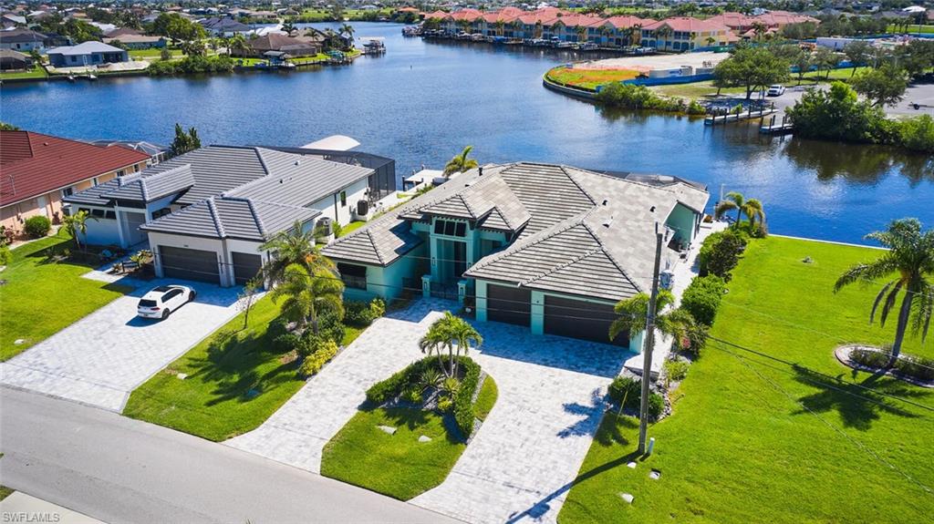 Welcome to the award-winning La Palma Estate by Tundra Homes—an extraordinary Gulf-access home, Pristine location, Amazing Gulf access water-view, with The Luxury Seven-Islands development coming soon — minutes away.” elegant design and superior quality of construction, built at a high elevation for safety and peace of mind, another important one is the Hurricane was no match for this Tundra-built home - it stood strong with No Damage- isn't that good to know! This 2,892 sq ft residence delivers the finest in Florida coastal living. Curb Appeal & Entry Set behind iron entry gates, the home features a tile roof, decorative shutters, circular driveway, LED lighting, and dramatic 10-ft steel hurricane-impact double doors. Brick pavers extend 4 ft wide along the right-hand side of the property from front to back. Interior Design & Layout The foyer leads to a spacious den with tray ceilings, frosted 8-ft barn doors, and a built-in desk. The open floorplan includes a formal dining room, a living room with Hunter Douglas automatic blinds, motorized curtains, and a mirrored bar sink—perfect for entertaining. Chef’s Kitchen & Finishes A showstopper kitchen boasts two 10-ft quartz islands, premium cabinetry, a walk-in pantry with built-ins and a second refrigerator, and top-of-the-line Thermador gas cooktop and oven for culinary excellence. Master Suite Retreat The master suite features tray ceilings, ambient lighting, electronic curtains, and a walk-in closet with automatic lighting. The luxurious bath includes dual vanities, a high-end bidet toilet, and a large walk-in shower. French doors lead directly to the pool. Guest Quarters Two guest bedrooms include one en-suite with walk-in shower, and one adjacent to a guest bath. A separate half bath near the lanai serves as the dedicated pool bath. Laundry, Garage & Systems The laundry room offers top-tier appliances and built-ins. The 3-car garage has epoxy floors, Lennox A/C with APCO X purification, central vacuum, and a whole-house water filtration system. Outdoor Living at Its Finest Massive pocket sliders open to a screened lanai with cool-to-touch white travertine, gas fireplace, and 3 ceiling fans. Enjoy a fully equipped outdoor kitchen with Broil Master burners and a refrigerator—perfect for al fresco dining with breathtaking 180° waterfront views. Waterfront & Boating Amenities The 25-ft heated pool features 3 fountains, a sun shelf, and large jacuzzi, all remote controlled. The waterfront includes a 10,000 lb Golden Boat Lift, Composite Trex decking on the dock with Trex-wrapped pilings, jet ski lift, and 10-ft wide boat slip installed by Stokes Marine. Dock includes electric, water, solar lighting, and a side-yard storage area for boating gear. Additional Highlights 24k whole-house Generac generator w/500-gallon buried propane tank Security camera system Minutes to shops, restaurants, Quick boating access to Matlacha Pass—boating here is phenomenal, TOO MANY UPRGADES TO LIST!